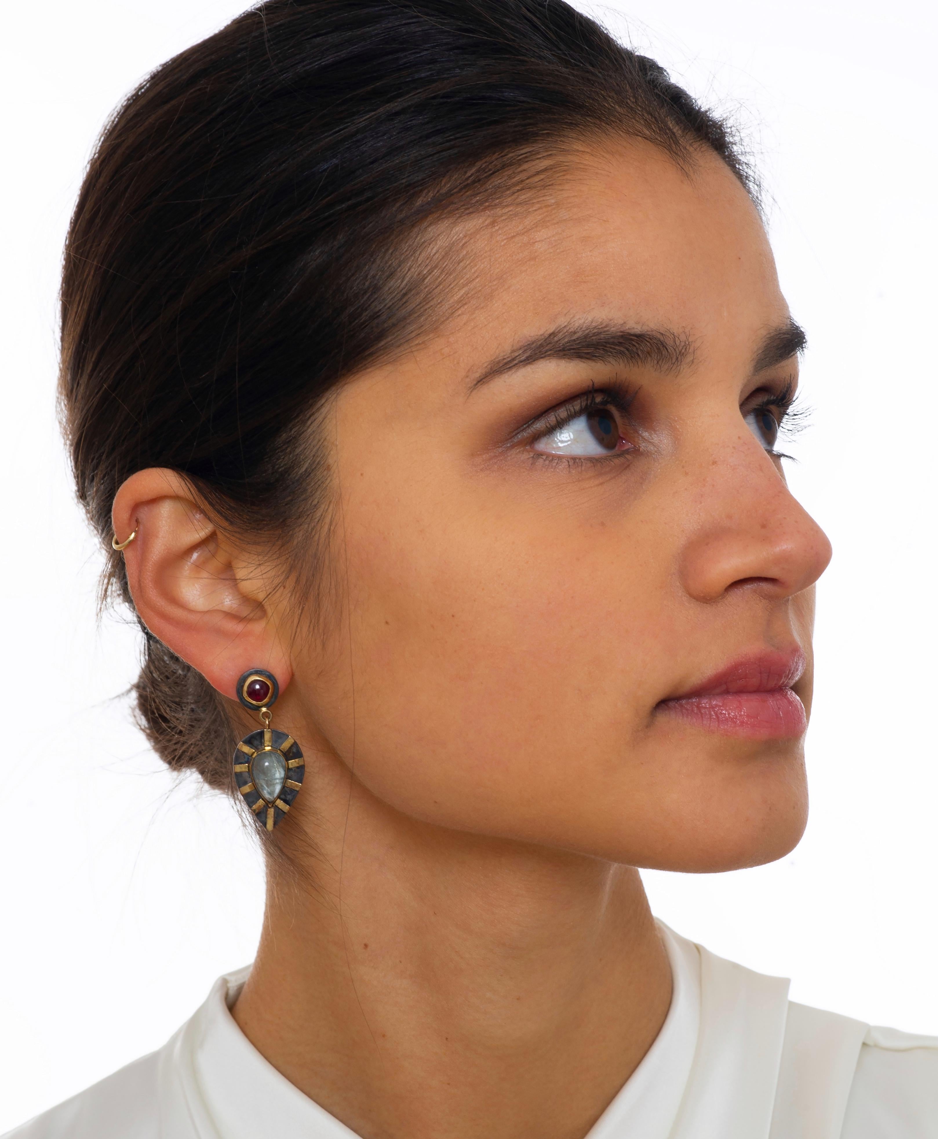 With their vibrant, eye-catching color and bold design these handmade, one-of-a-kind earrings are a stunning addition to your jewelry wardrobe. 
The aquamarine drops are wrapped in 18K gold bezels and set on a frame of blackened sterling silver