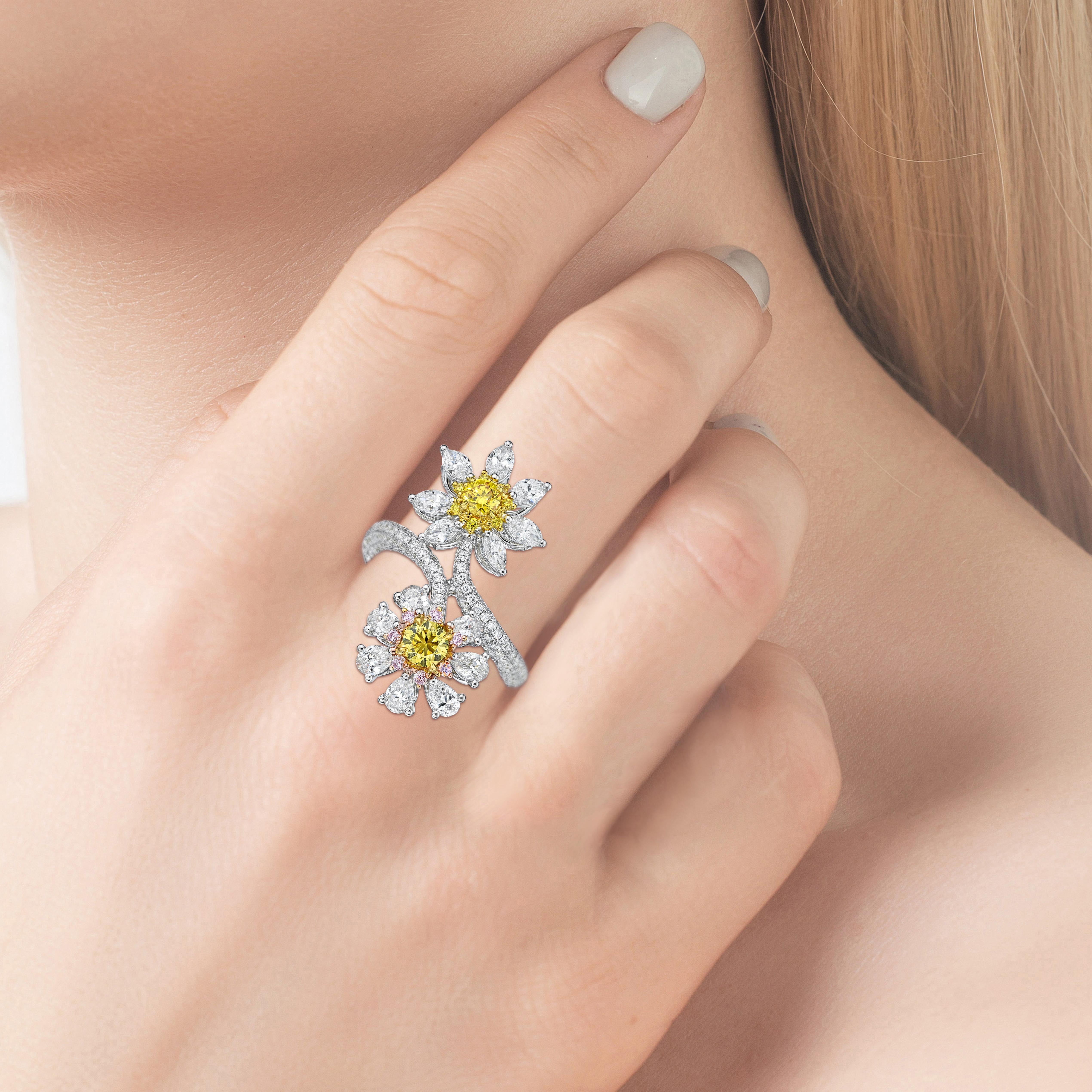 This fascinating cocktail ring is made in luxurious 18K white gold, featuring 2 GIA Certified Fancy Vivid Yellow Diamonds and designed in 2 different colors, Daisy by yellow and pink diamonds on the halo with white diamond. Fancy diamonds in round