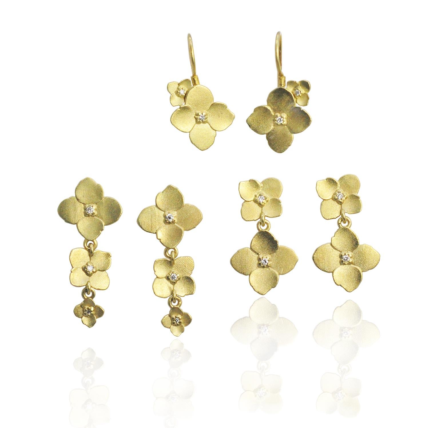 Drei gestapelte Hortensienblüten aus 18 Karat Gold mit Diamanten in der Mitte bilden diese süßen Ohrstecker. Große, mittelgroße und kleine Blüten hängen an den Ohrringstiften nach Größe ab. 

Wir bieten auch goldene Hortensien-Ohrringe mit doppelter