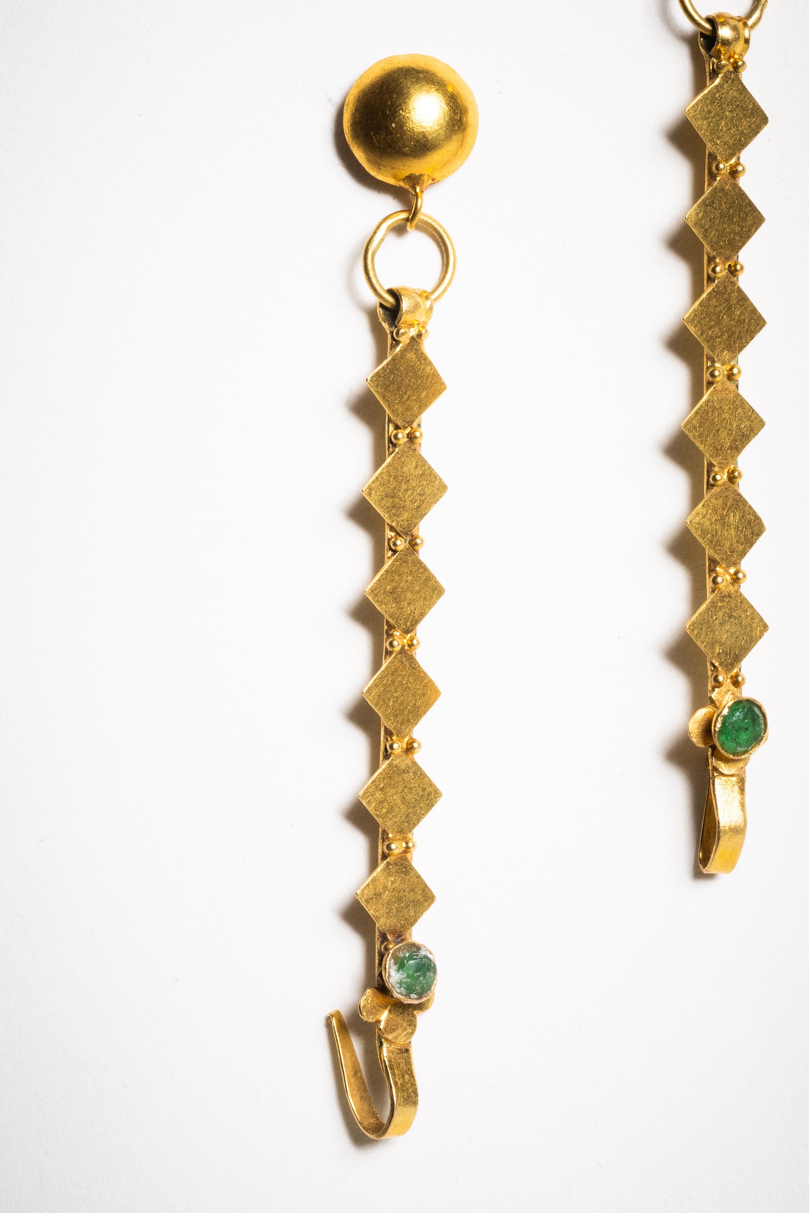 These dangle earrings were not always earrings. From India in 18K gold, these were on the ear and then hooked onto a woman's hair as an added adornment. We added the matte finish ear wire at the top. A faceted emerald at the bottom. A rare