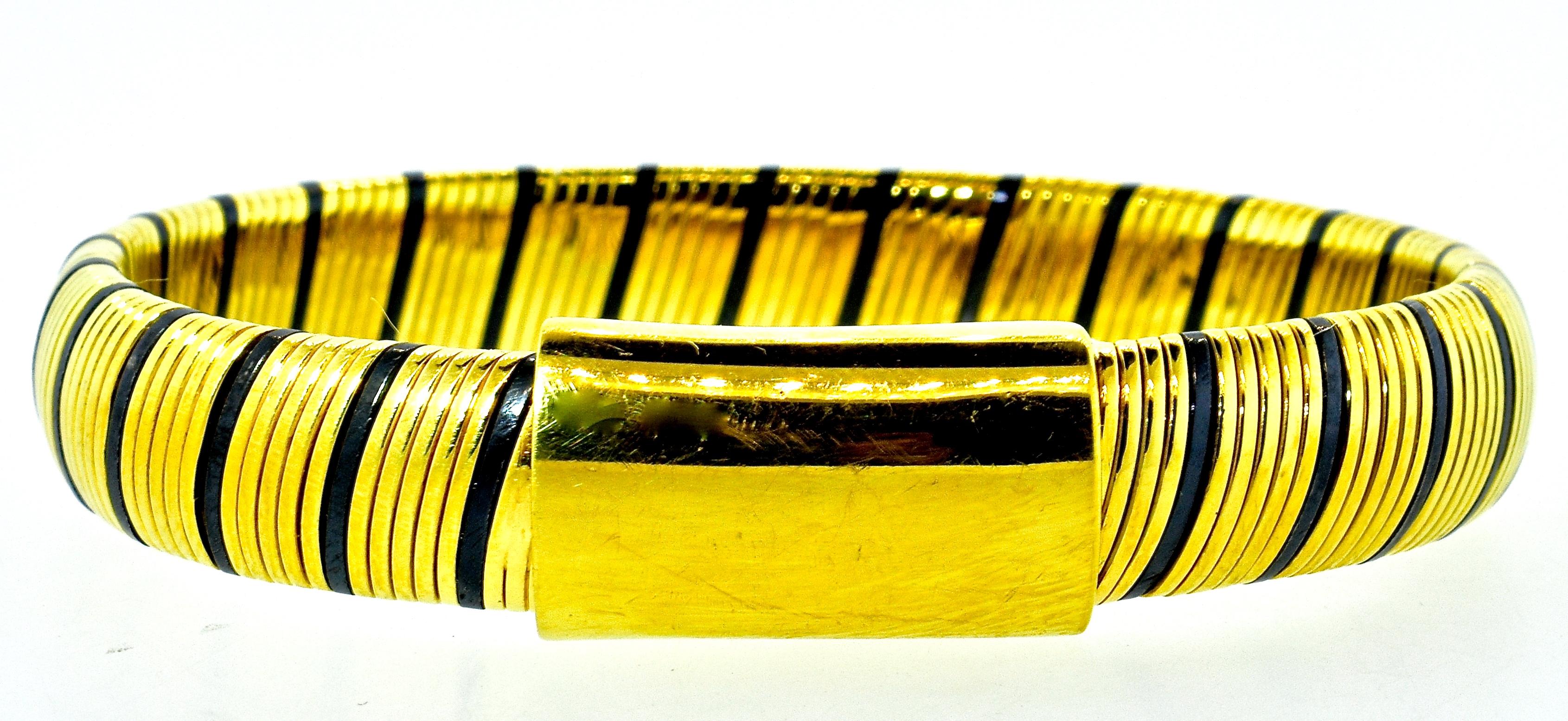 18K and black enamel bracelet which opens and expanse about an inch for ease of putting on.  This 18K ( marked 750) bracelet with stripes of black enamel weighs 44 grams.  When closed the interior dimensions is 6 inches and the width is 3/8ths. 