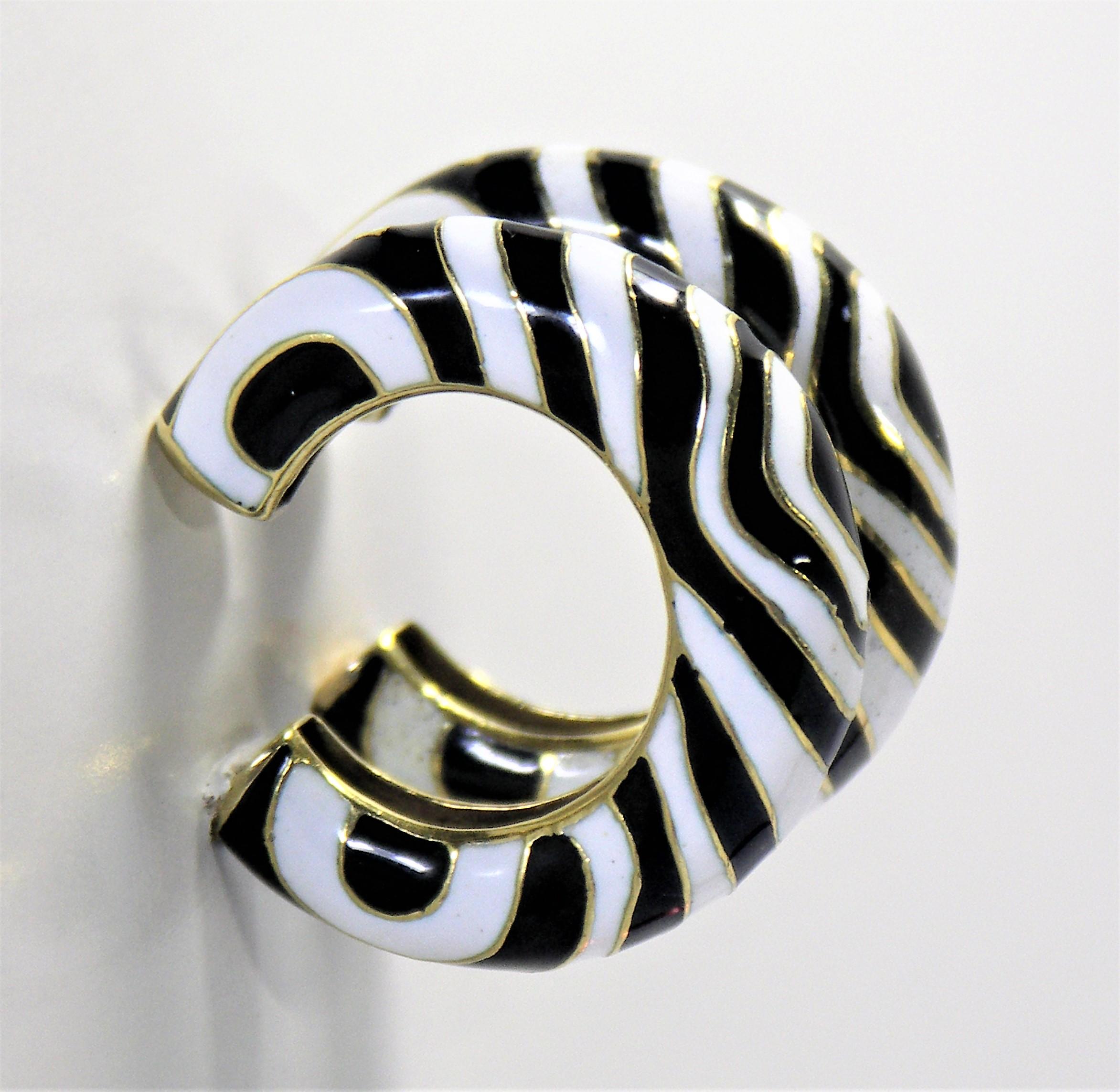 Made of 18K Yellow Gold with alternating zebra stripes of black and white cloisonne enamel.
These beautifully crafted clip on earrings measure 3/8 inch wide by 1 5/16 inch in diameter.  Weight is 33.3grams.