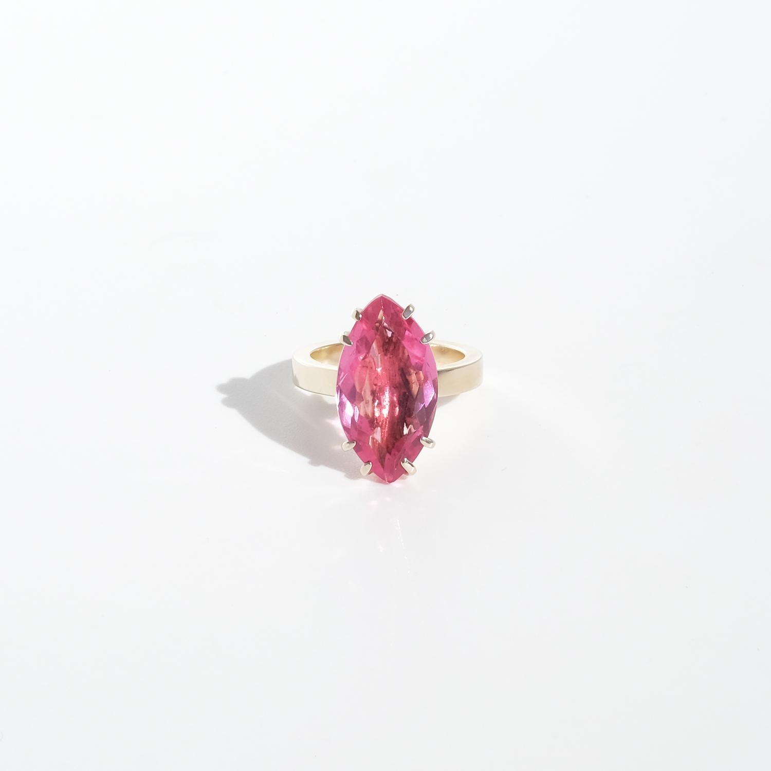Questo elegante anello in oro a 18 carati presenta una pietra di vetro rosa tenue dal taglio ovale con una superficie liscia e luminosa. La pietra è tenuta saldamente da otto delicate griffe lucidate che ne esaltano la raffinata semplicità. Il