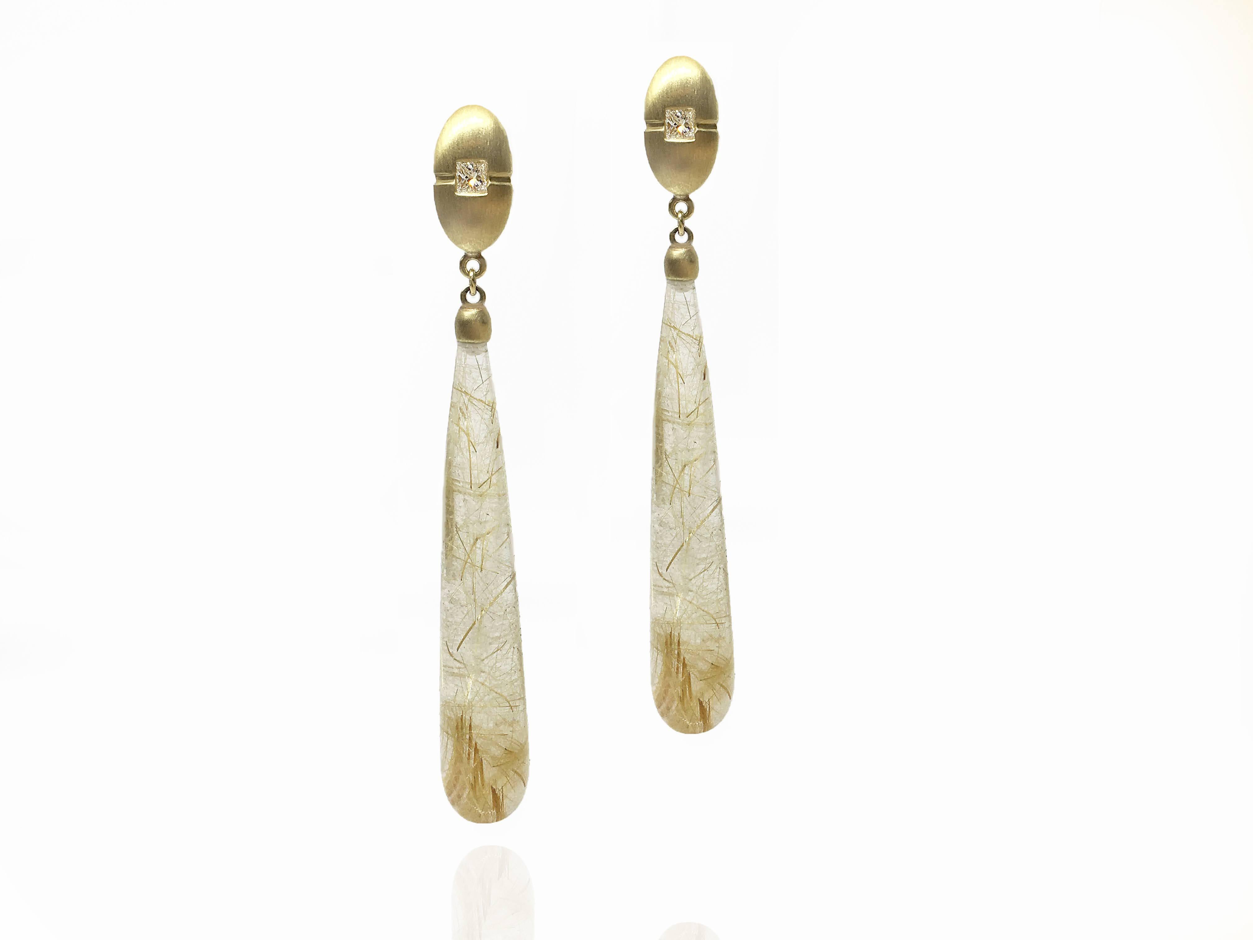 These elegant one-of-a-kind rutilated quartz long drop earrings are sourced from and cut in Brazil. With exceptional clarity and lovely strands of rutiles growing within the quartz give the impression of woven strands of gold within. The long drops