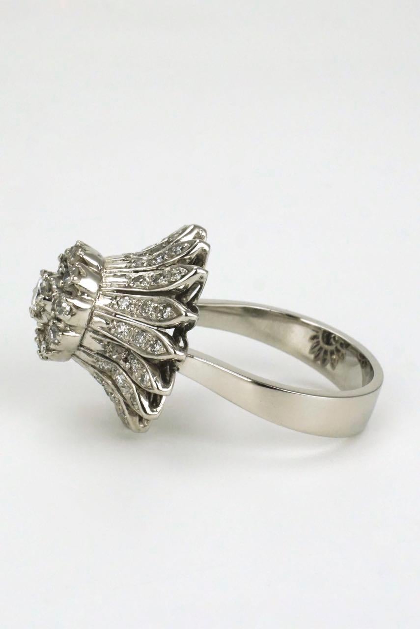 A diamond oversized daisy flower ring  - this unique and playful design consists of a central round brilliant cut diamond set within a halo of ten single cut diamonds and raised above 16 petals set with a further 48 single cut diamonds set in silver