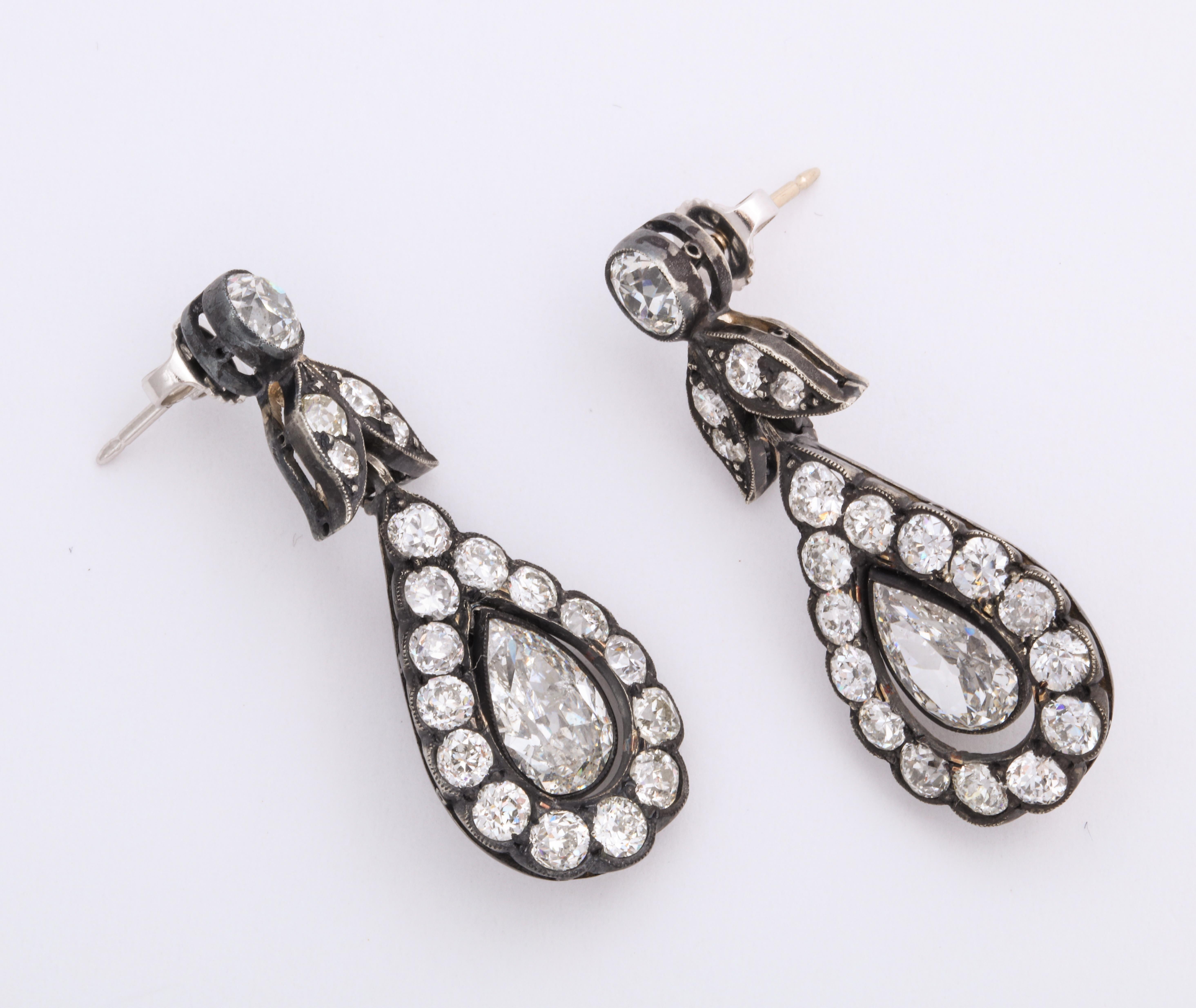Classic Georgian diamond earrings are high contrast drama! These diamond drop earrings are fashioned in silver-topped 18K gold and have over 6 carats of bright white old mine cut diamonds in a typically symmetrical pendant design for the ear.  Not