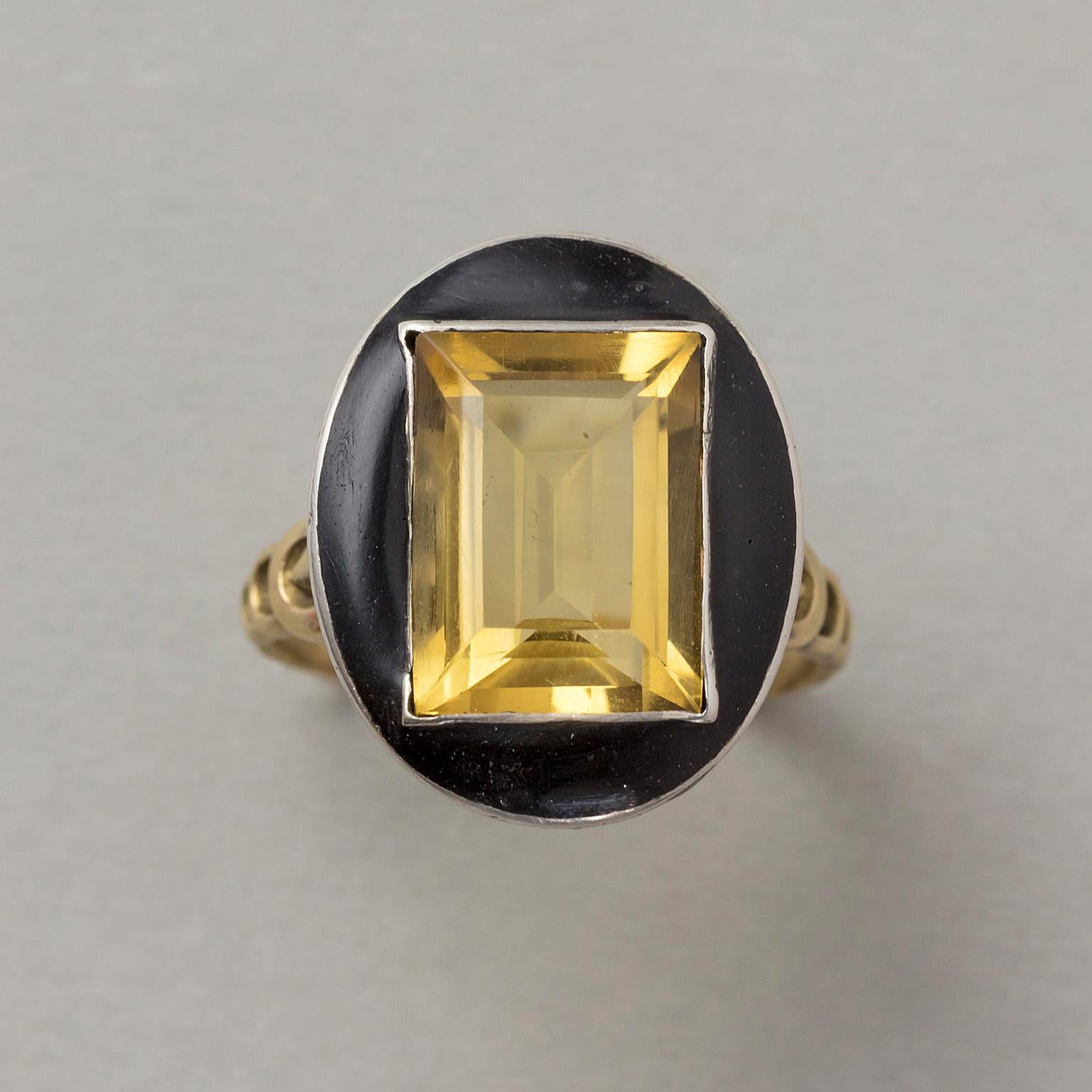 This French Art Deco ring features a large step cut citrine that pops from a black enamel frame all set in silver with the most gorgeous 18 carat gold geometrical gallery and shank, circa 1920.

weight: 6.43 gram.
ring size: 19- mm. / 9 US.