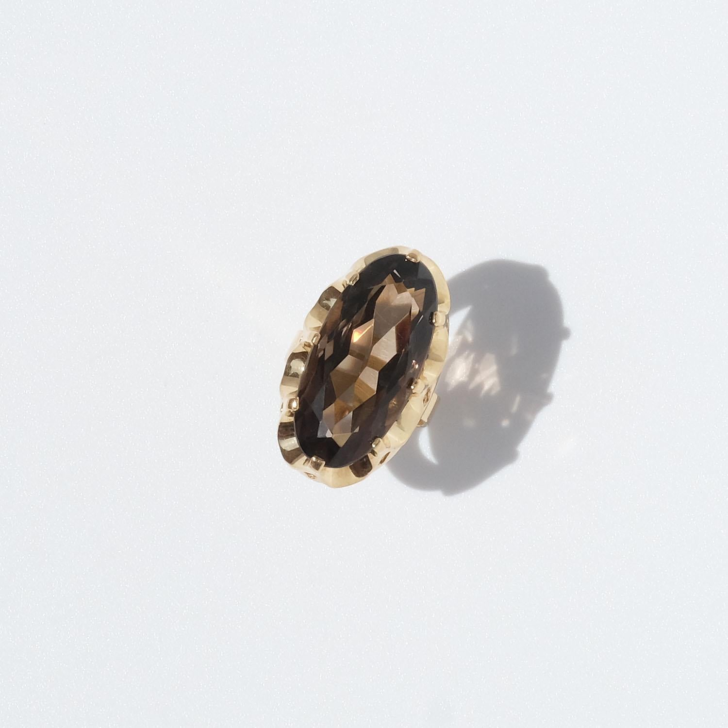 This 18 karat gold ring is adorned with an oval shaped, faceted smoky quartz. The smoky quartz is held by an amazing setting which resembles a king's crown. 
This is a cocktail ring worthy of the name. It is prominent but yet elegant.
The condition