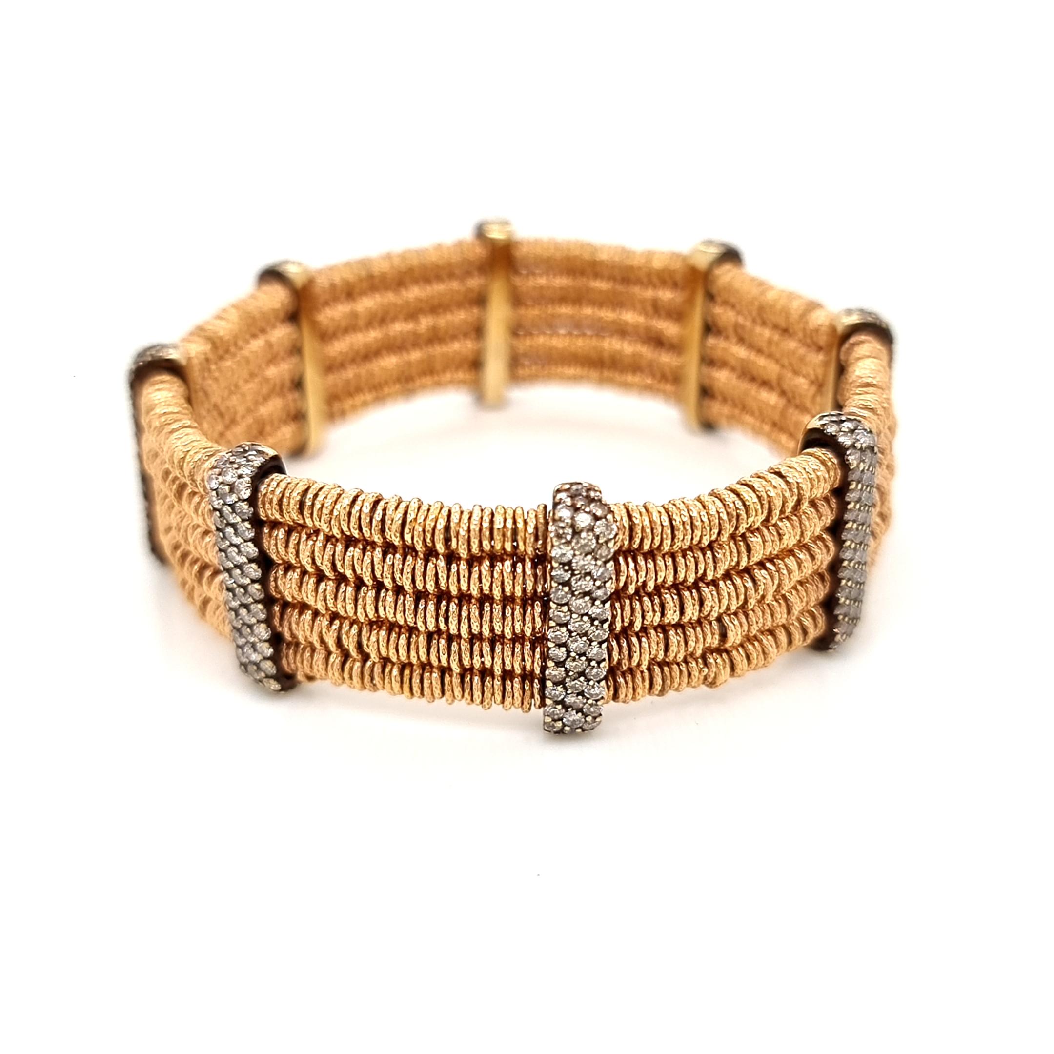 Experience the epitome of style with this designer bracelet, a masterpiece by Roberto Demeglio. Boasting a unique blend of stretchable steel insides and opulent 18K yellow gold elements adorned with encrusted brown diamonds, this bracelet exudes