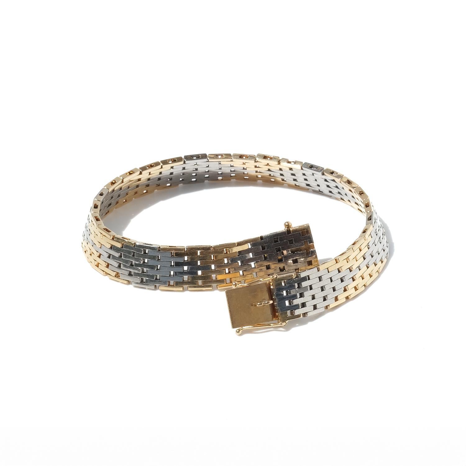 This bracelet is crafted in 18-karat yellow gold and white gold, featuring a distinct pattern of flat rectangular links that reflect light in a unique way, often referred to as a 