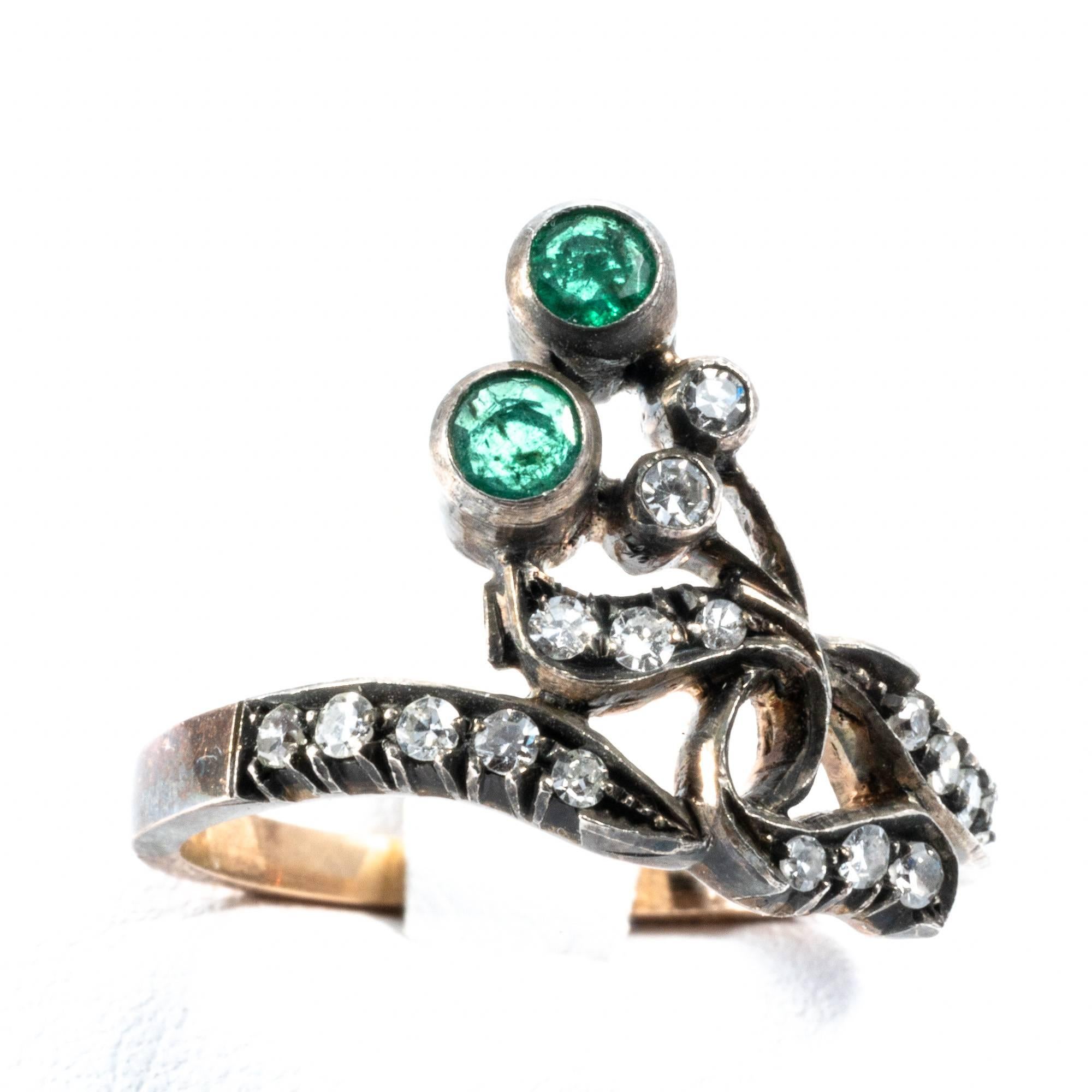 Original vintage ring band manufactured in the 1920's, it shows the typical symbol of the love tie, featuring a ribbon-like knot.  Sleek and elegant, this ring has 2 round cut emeralds and 18 diamonds that enlighten it's delicate swirls.
Actual ring