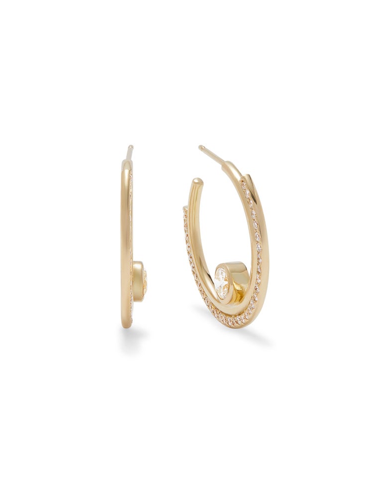 Architectural yet minimal hoop earrings in 18K yellow gold. The hoops feature brilliant cut bezel set center diamonds and modern banded detail on the edges set with pave diamonds . Total diamond weight is 1.83 carats.
