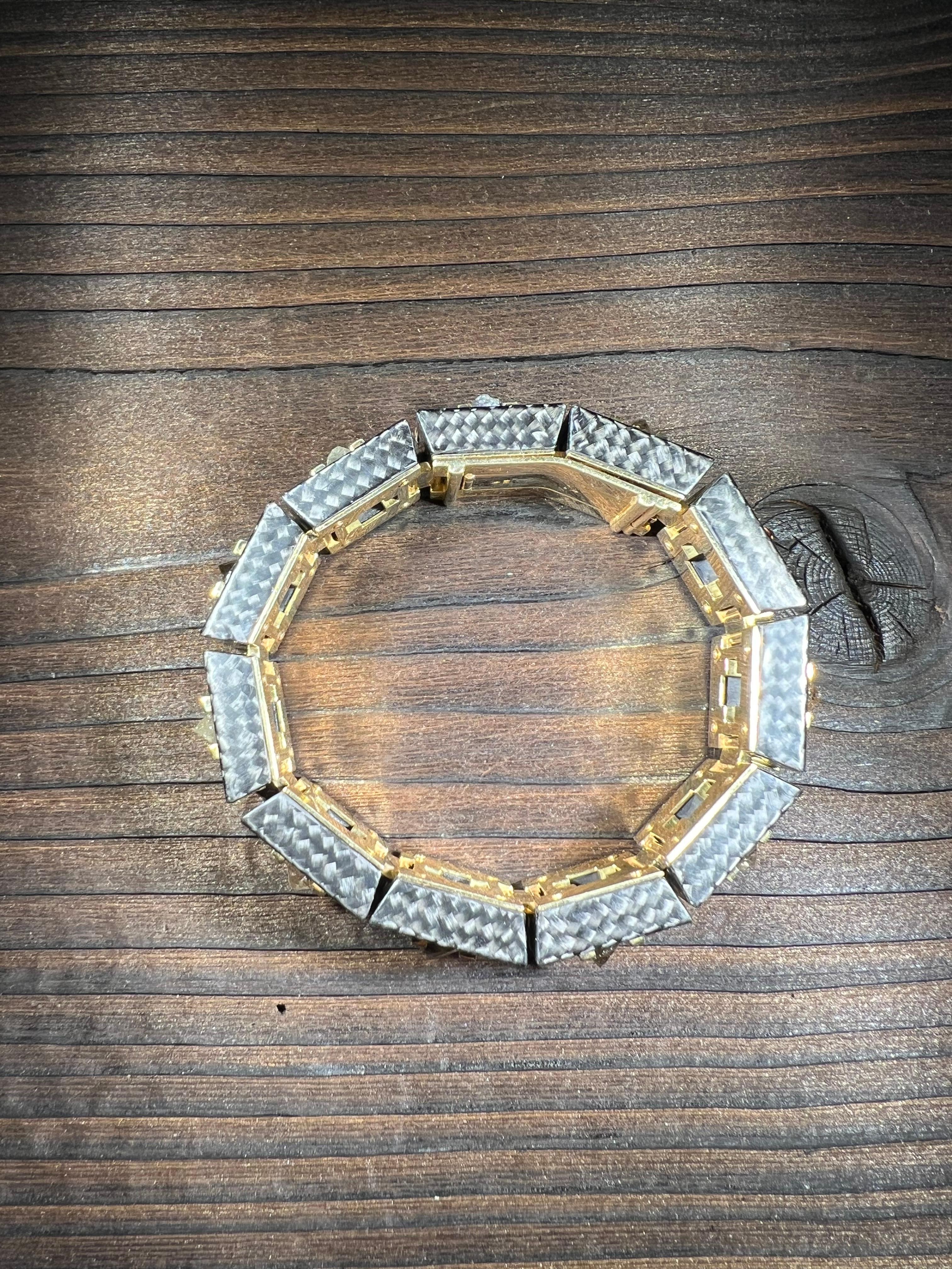 Ein Armband, das in seiner Modernität und Eleganz einzigartig ist. Die 11 Rohdiamanten, mit einem stolzen Gesamtgewicht von 30,4ct, meisterhaft in Gelbgold eingefasst und von edlem, schwarzem Karbon umgeben, ziehen alle Blicke auf sich und verleihen