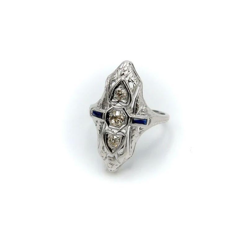 This is a stunning Art Deco navette-shaped filigree white gold, diamond and sapphire ring. The ring is set in a 18 karat white gold filigree mounting with three European cut diamonds arranged in a line at the center, with two of these encircled in a