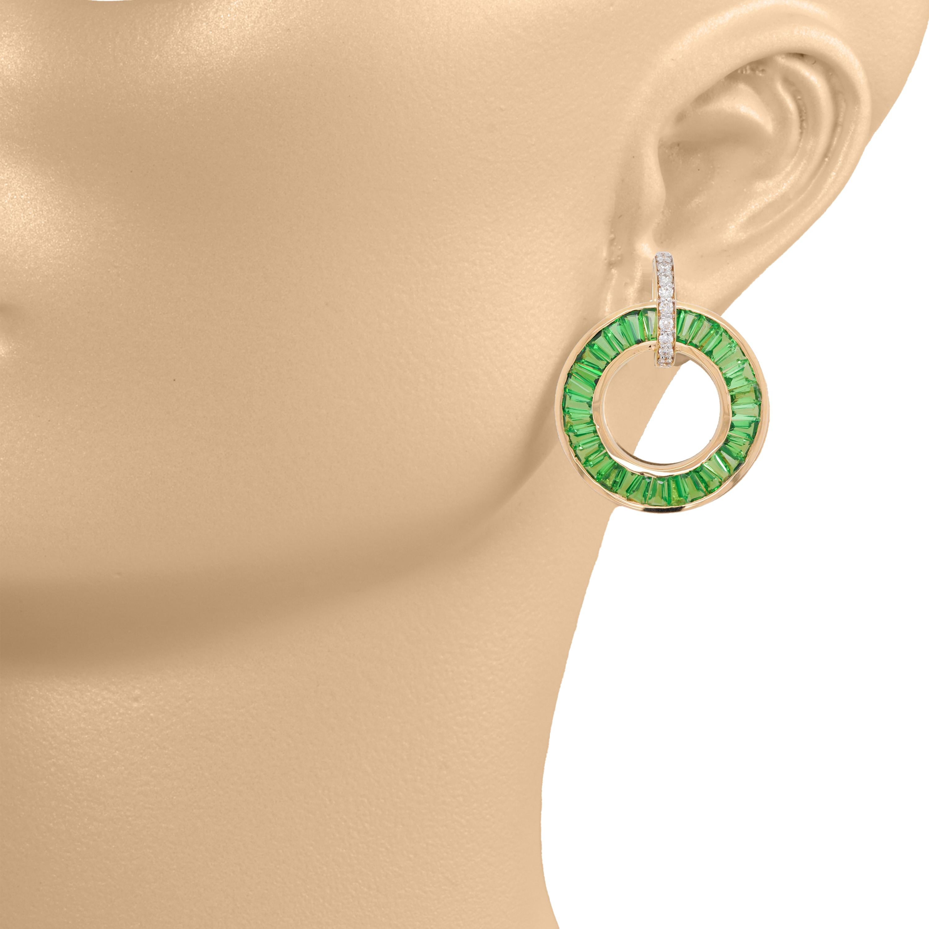 Indulge in the timeless allure of these Art Deco-inspired earrings, crafted in exquisite 18 Karat gold. Designed to captivate and enchant, these circular earrings features a stunning arrangement of Tsavorite garnet baguettes, expertly channel set to