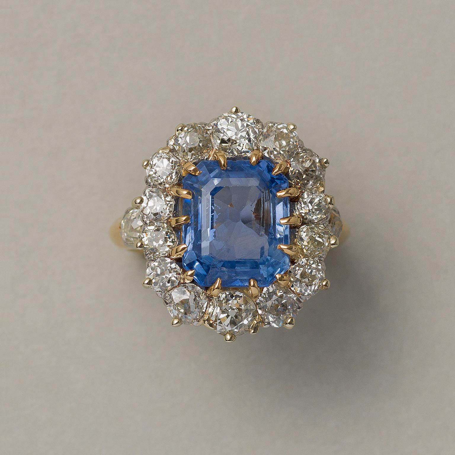 Ein prächtiger französischer Ring aus 18 Karat Gold der Jahrhundertwende mit einem smaragdgeschliffenen, hellblauen, ungeschliffenen Sri-Lanka-Saphir (ca. 5,13 Karat) und 14 Diamanten im Altschliff, die den Ring umgeben, sowie zwei Diamanten an der