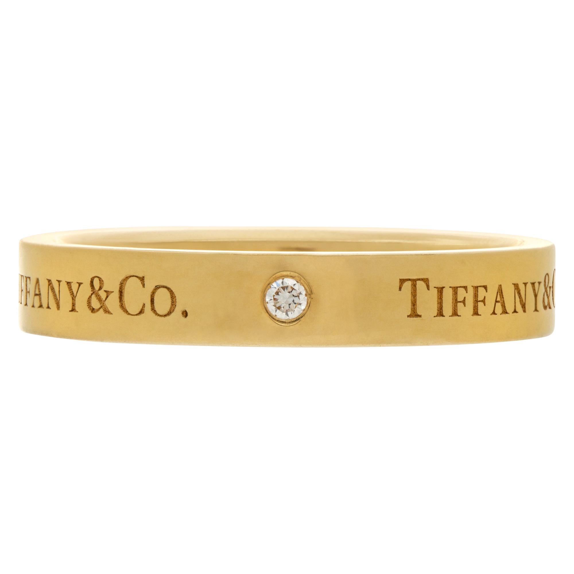 Tiffany & Co. 18k gold band ring with three round brilliant diamonds. 4 mm wide. Size 9.75.<br /><br />This Tiffany & Co. ring is currently size 9.75 and some items can be sized up or down, please ask! It weighs 3.7 pennyweights and is 18k.
