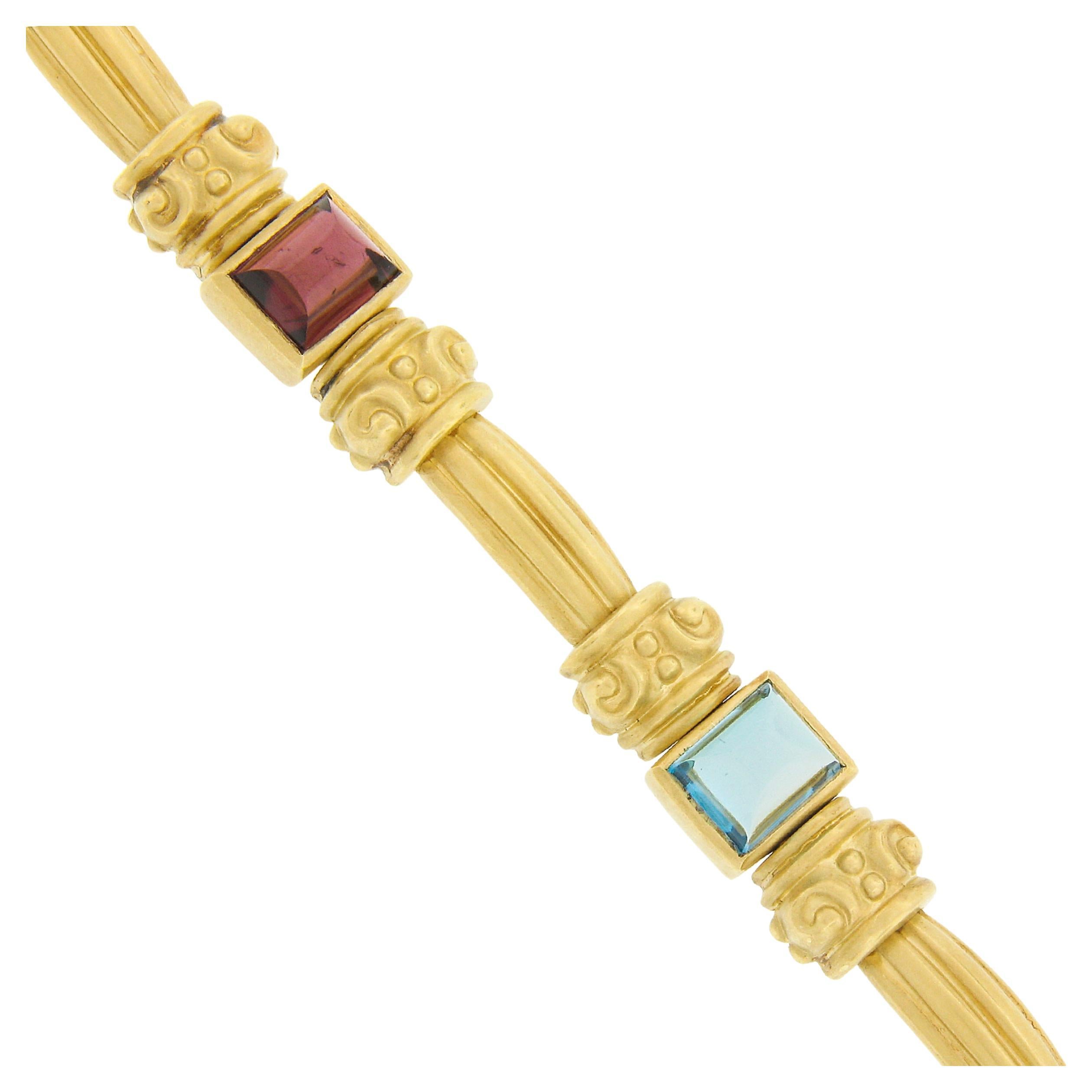 This uniquely designed and well made vintage statement bracelet is crafted in solid 18k yellow gold and features 4 natural genuine gemstones that are neatly bezel set throughout. These high quality rectangular cabochon cut stones include amethyst,
