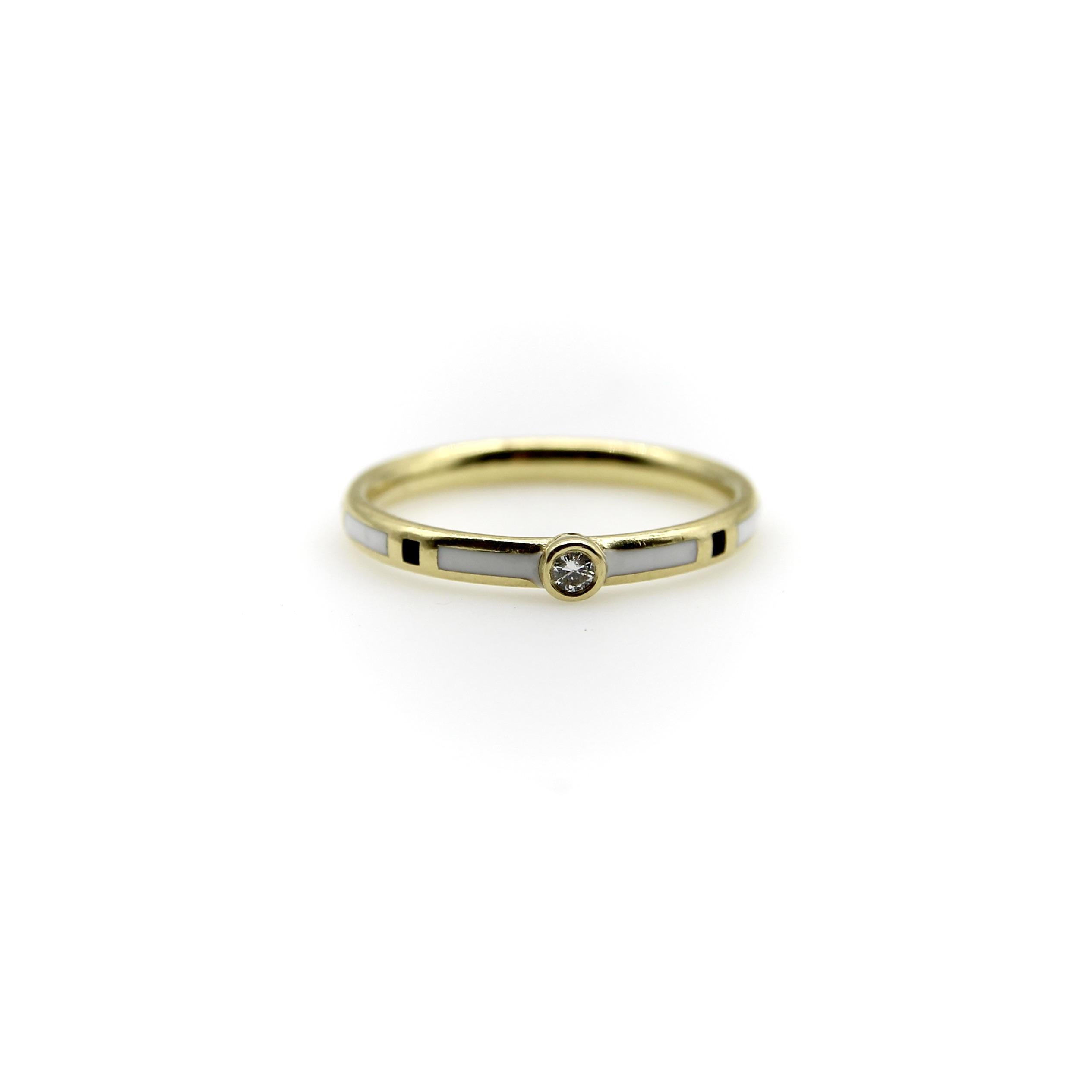 This 18k gold band is detailed with a rhythmic patten of white and black enamel, accented by a bezel set diamond. Enameling is created by carving out reservoirs within the gold, then filling the empty space with enamel. This ring has a great display