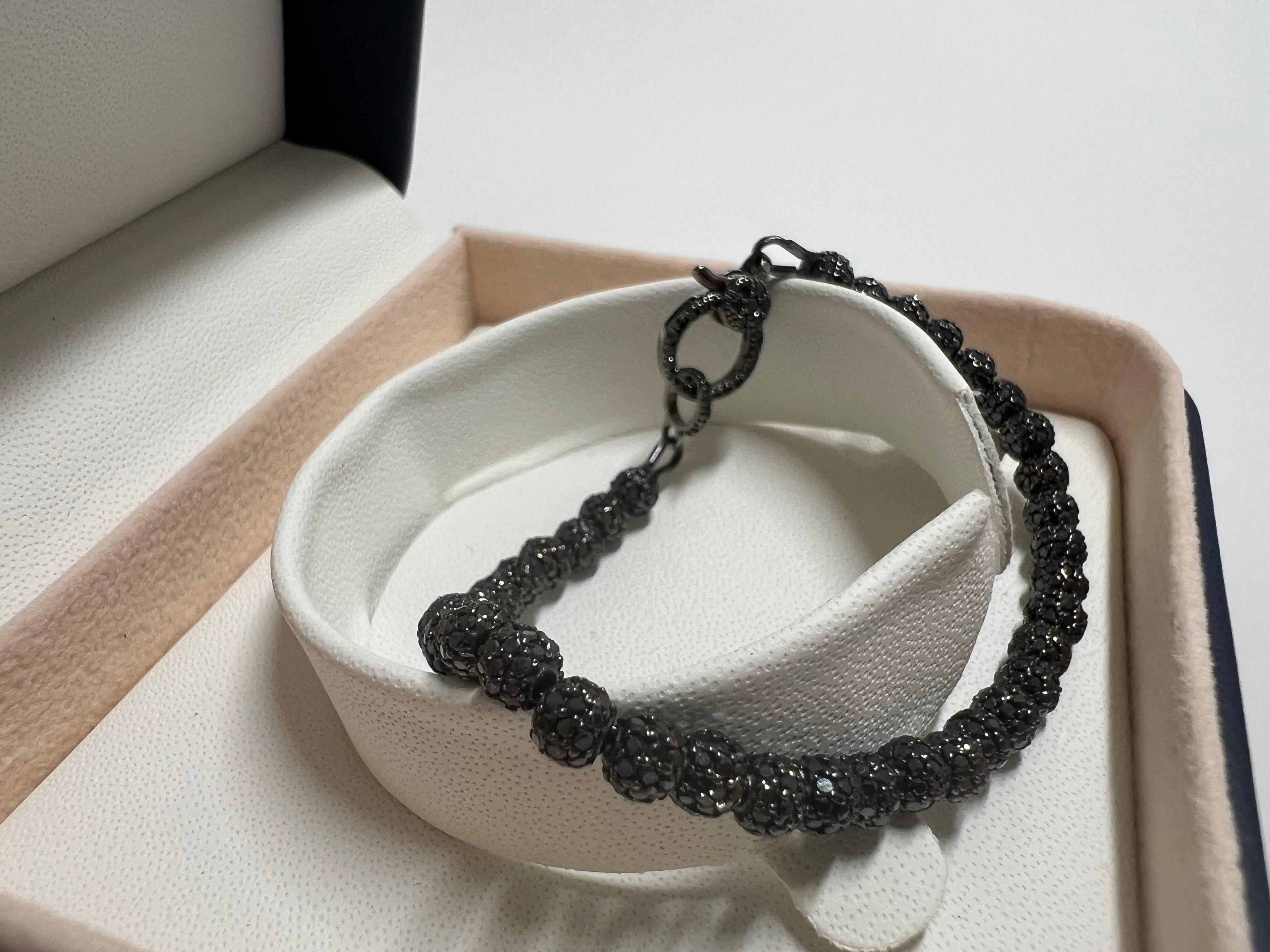 Prova la brillantezza del nostro Bracciale Tennis con diamanti splendidamente reinterpretato, realizzato a mano in elegante oro nero rodiato a 18 carati e dotato di circa 6,5 carati di diamanti neri. Questo pezzo unico è impreziosito da diamanti su