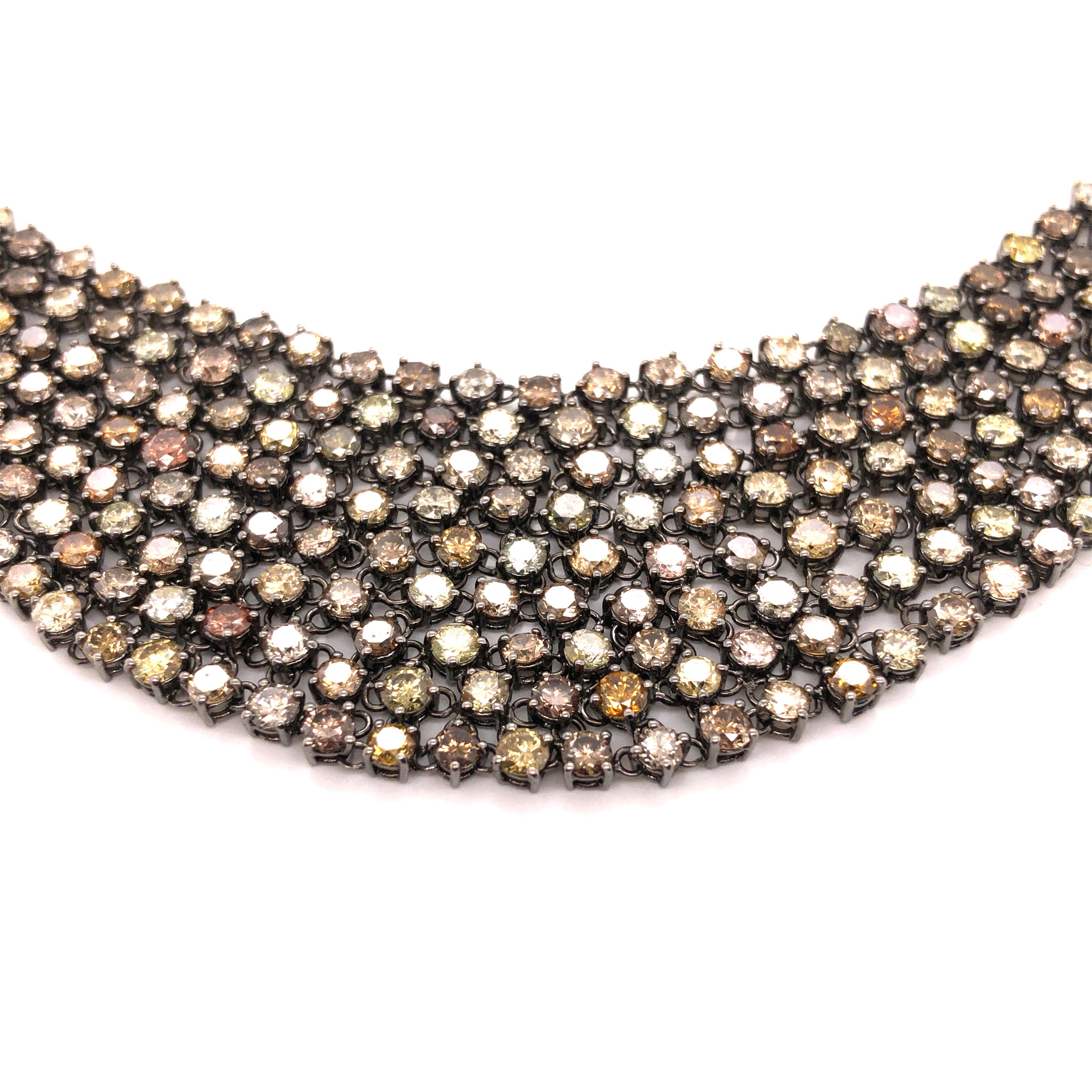 An 18K gold black rhodium necklace featuring a mix of white, brown, yellow, and orange round-cut diamonds weighing a total of 30.69 carats.

Stone: Diamond ~ 30.69

Metal: 18K Gold

Size: 16