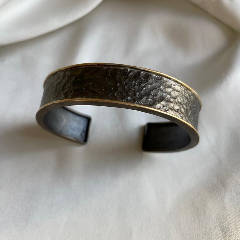 Light weight, yet substantial feeling, this mixed metal cuff is a nice piece of men's jewelry.  The hammered and blackened silver is very rich and has a strong look.  Not too wide so it will be comfortable.  