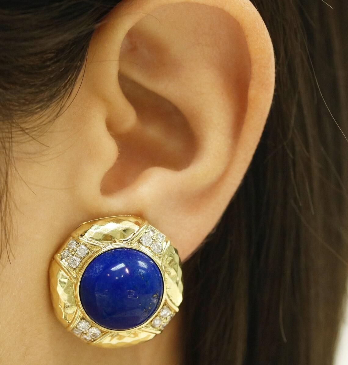 Featured is a gorgeous pair of blue lapis lazory and diamond clip-on earrings. The clip on's welcome a natural cabochon blue lapis. Specks of beautiful pyrite are seen running across the gemstones, more known as fools gold. Pyrite is a natural