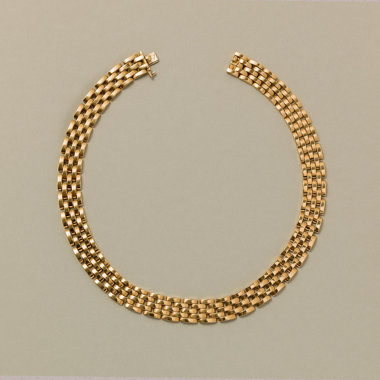 An 18 carat gold necklace, Panthère model, classic five-row choker necklace with a grain de riz pattern, signed and numbered: Cartier, 632144, French.

weight: 137.88 grams
length: 43 cm
width: 14 mm
