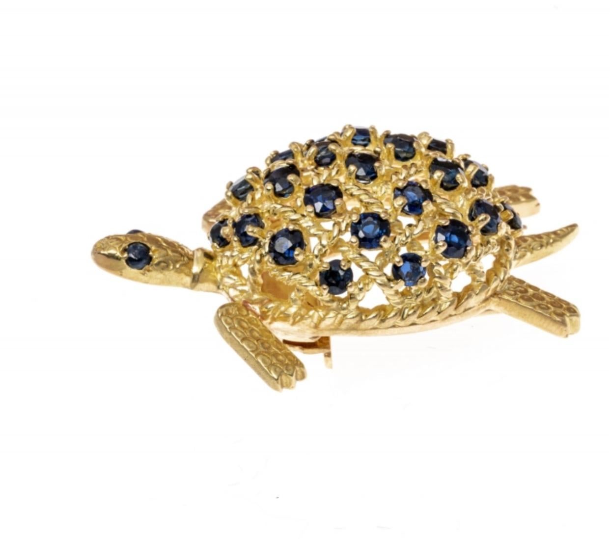 This charming and whimsical brooch is a turtle, set with a checkerboard of round faceted, medium to dark navy blue, sapphire stones, approximately 1.85 TCW, and prong set in between twisted gold criss-crossing wires. The head, feet and tail of the