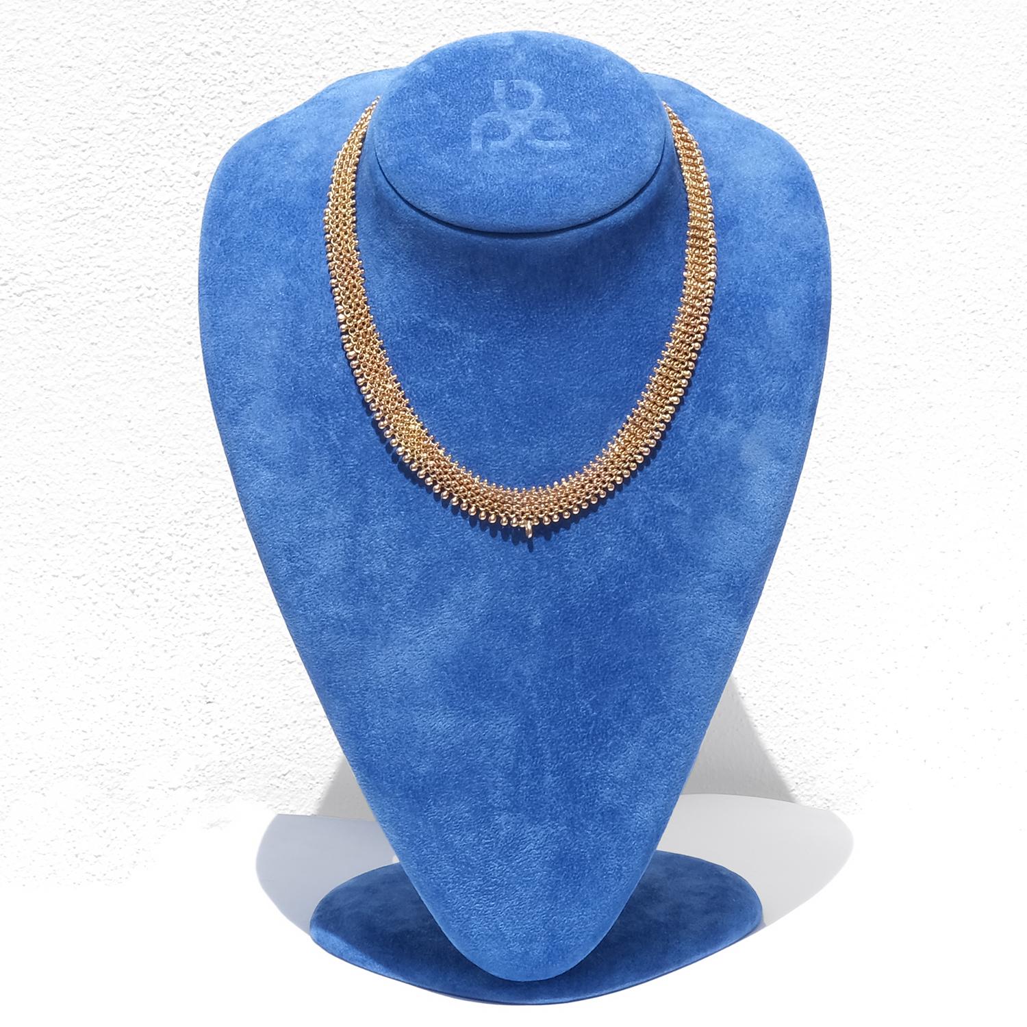 Ce collier est réalisé en or 18 carats et composé d'éléments arrondis étroitement liés entre eux qui créent une chaîne flexible tissée. Chaque maillon est formé de petites perles d'or polies, avec des 