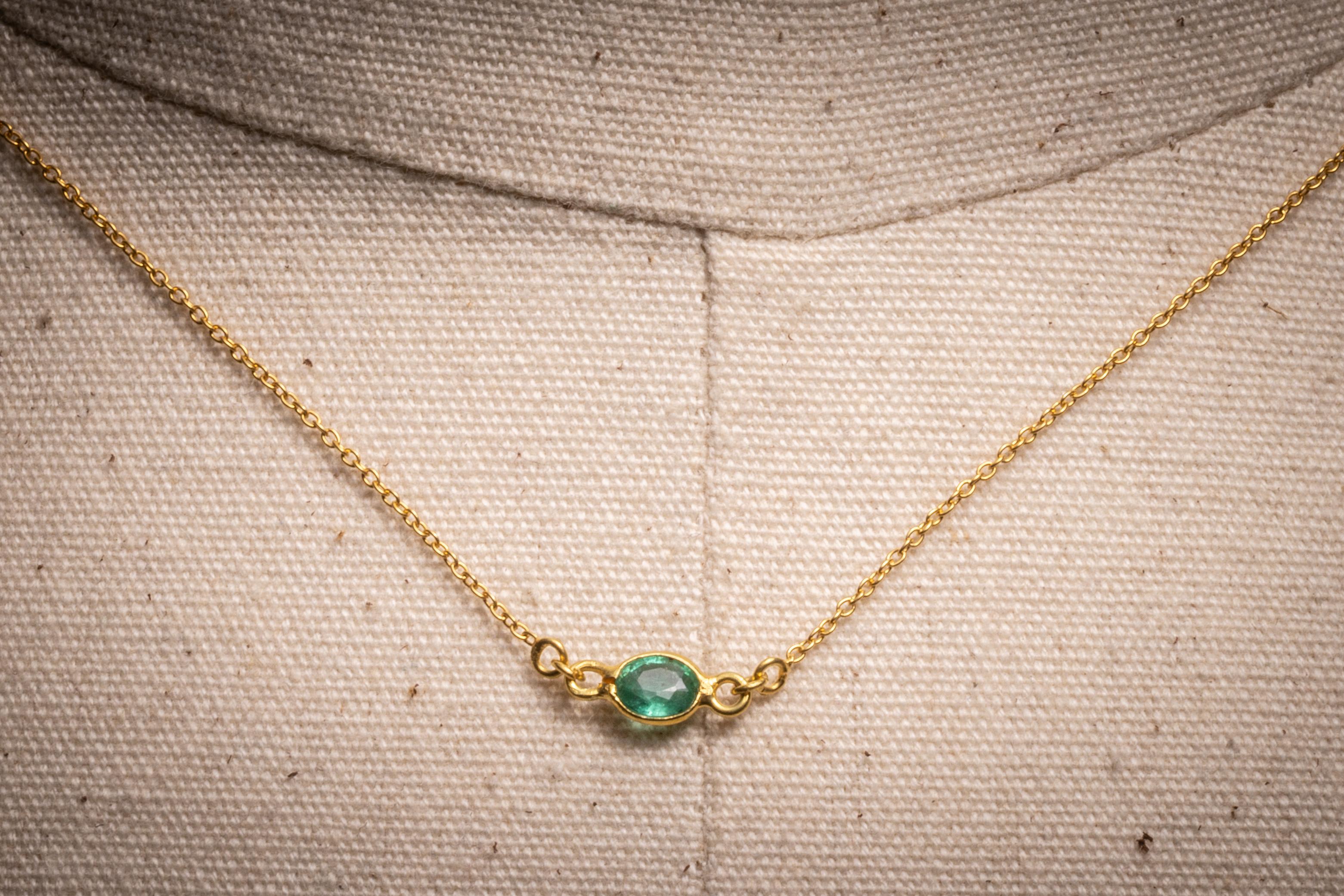 A lovely delicate chain necklace with three oval, faceted Colombian emeralds placed at the center and two at the collar bone.  S-hook clasp.
