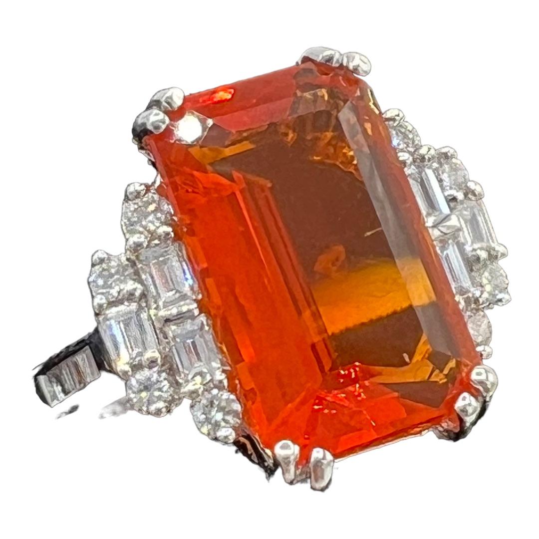 Superb ring in 18K white gold set in its center with a very beautiful fire opal, bright orange in color, rectangular in size and faceted, weighing 2.25 ct, surrounded by a paving of 6 calibrated diamonds and a diamond pavé for approximately 0.30ct