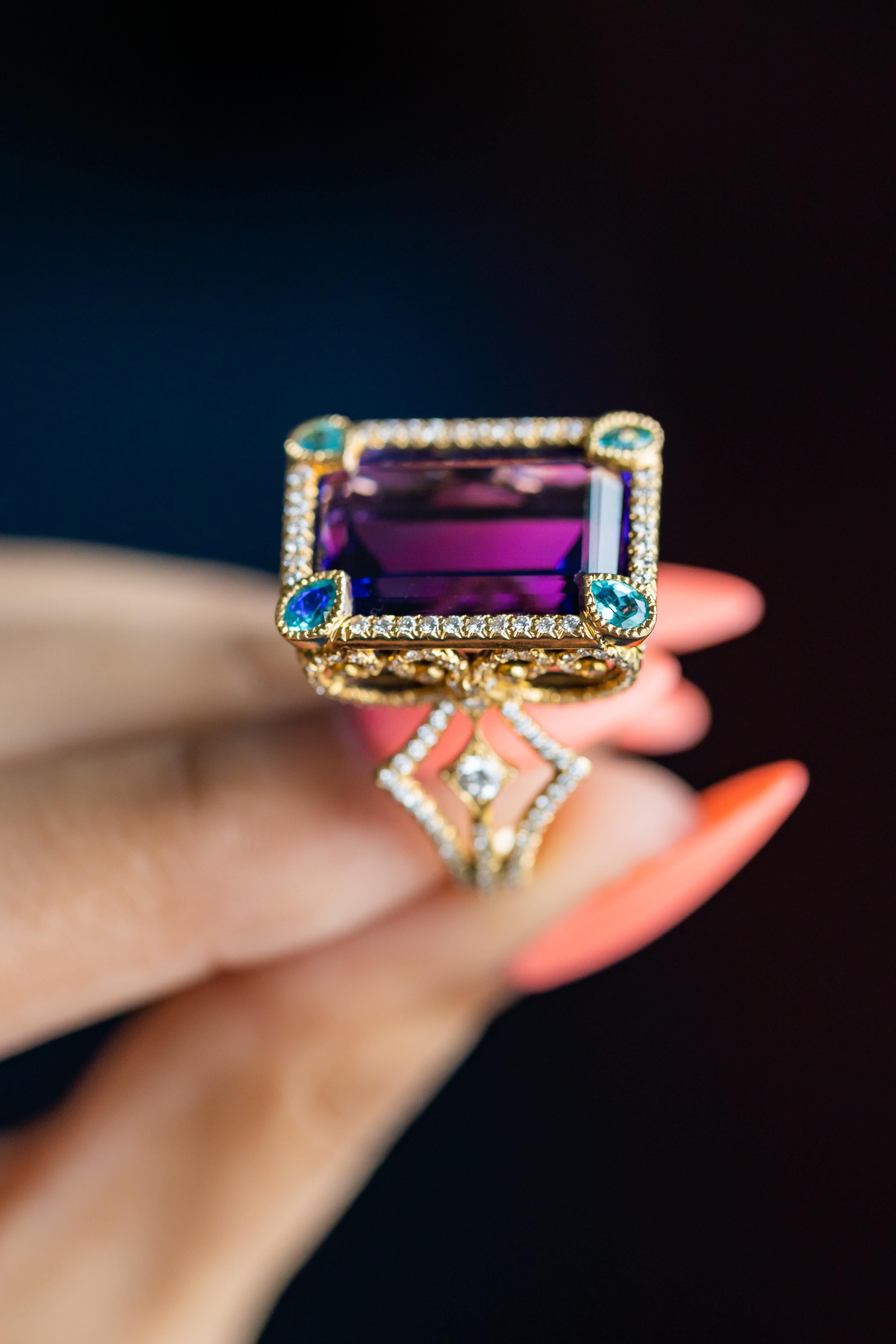 Step into a world of unparalleled elegance with the 18K Yellow Gold Coco Ring, a masterpiece from the renowned designer Erica Courtney. At the heart of this exquisite ring lies a breathtaking 24.21 carat Tanzanite, its deep, vibrant blue hues