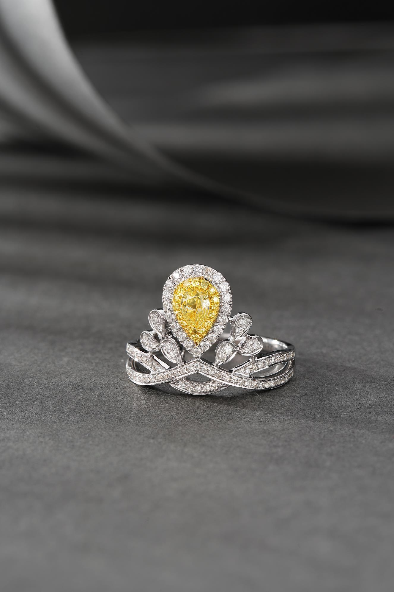 Parfaitement fabriquée à la main en or 18k, elle est mise en valeur par un superbe diamant jaune naturel de 0,30ct au centre. Le diamant en forme de goutte est serti dans une monture exquise et entouré de 0,45ct de diamants naturels étincelants,