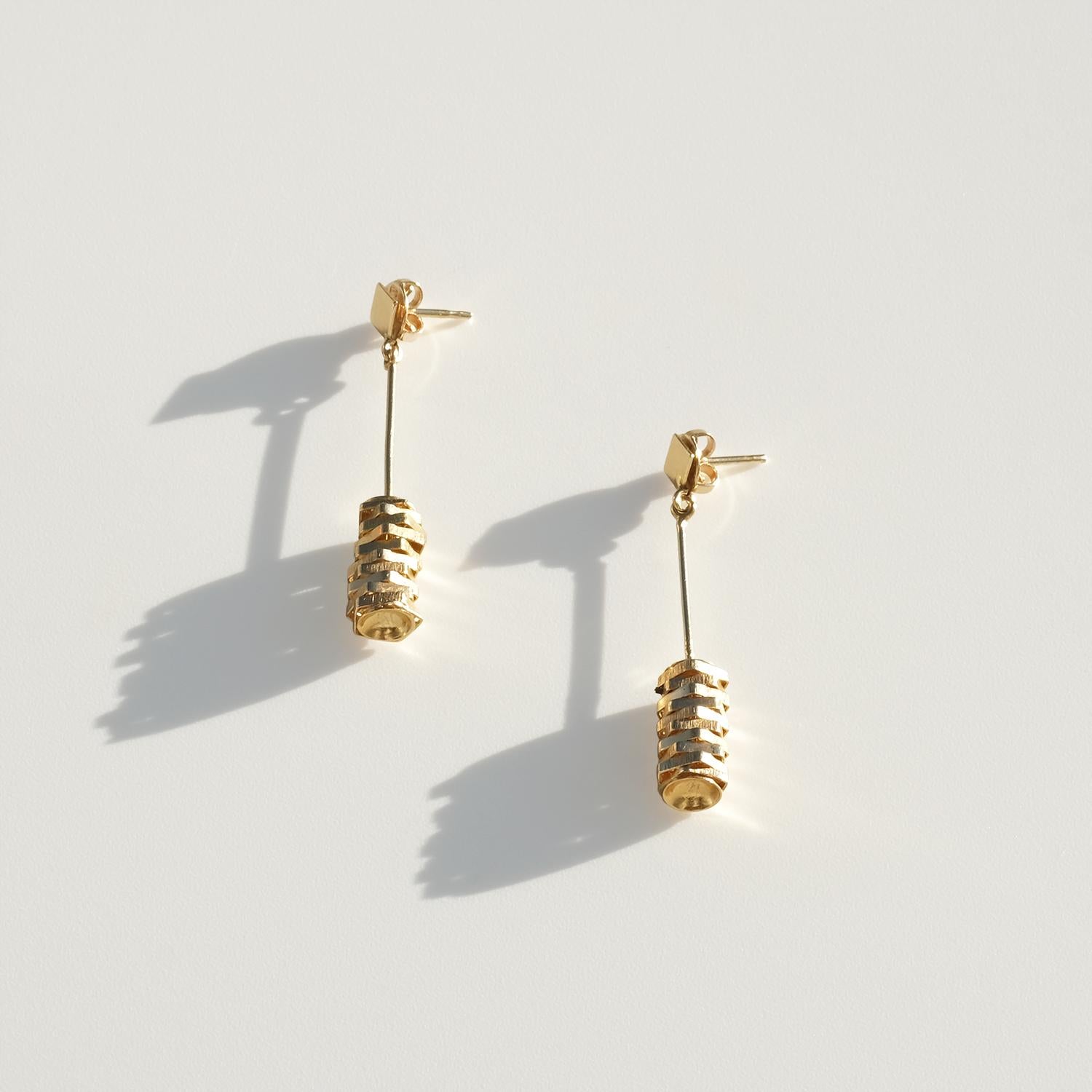 Questi orecchini vintage sono realizzati in oro a 18 carati e sono costituiti da perni pendenti allungati. Ogni orecchino inizia con un piccolo elemento superiore arrotondato, seguito da una barra sottile e dritta che crea una linea verticale