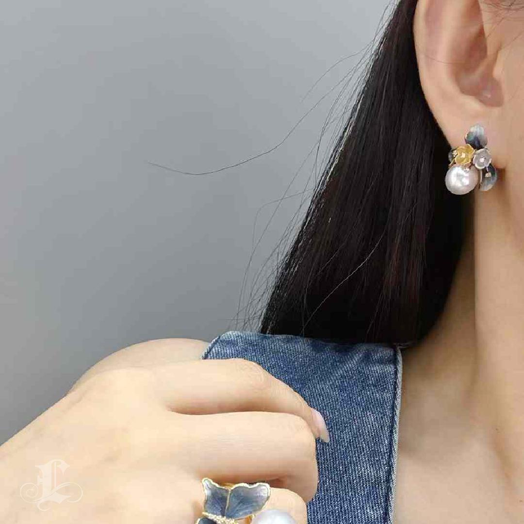A miniature garden of light and form, these earrings bloom with poetic elegance and technical mastery.
At the heart are luminous South Sea pearls, radiating a soft glow of natural elegance. Surrounding them, sculpted blossoms and leaves in 18K gold