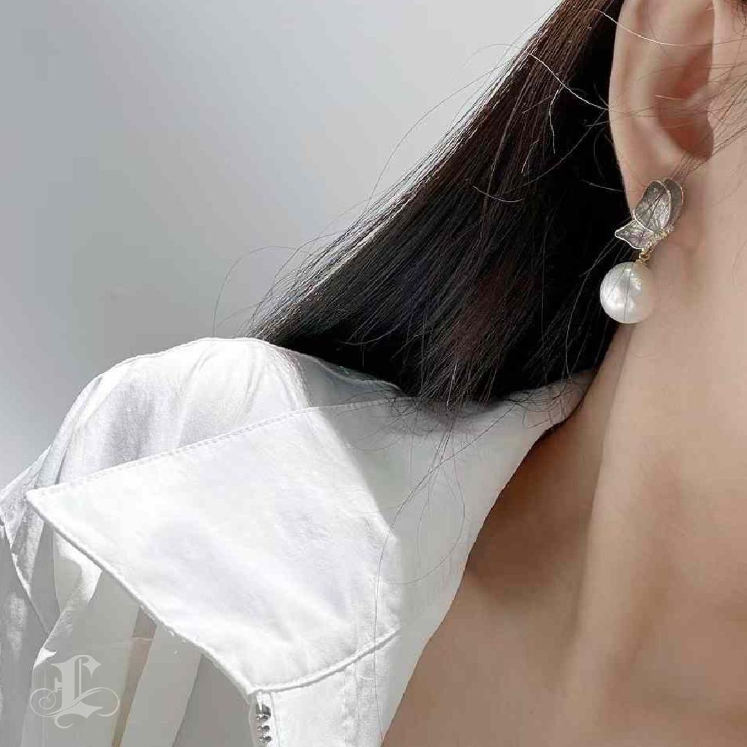 A dance of light, flight, and refined artistry.
These poetic butterfly earrings feature lustrous South Sea pearls gently cradled beneath sculptural wings, rendered in softly shimmering white gold. The wings are brought to life with a 