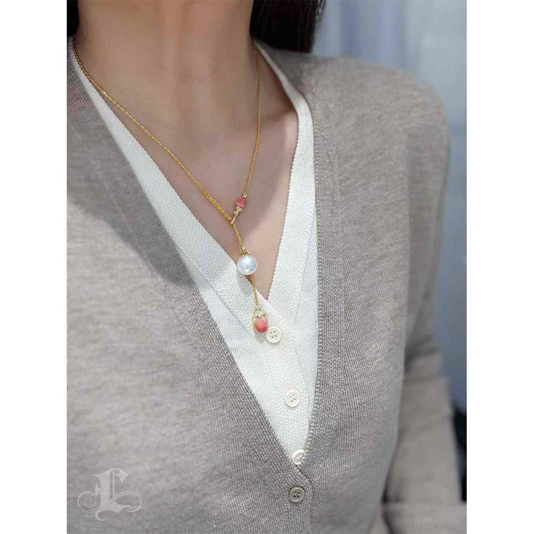 Un'accoppiata poetica di contrasto e unione, questa collana a Y presenta una rara coppia di perle di conchiglia rosa-arancio per un totale di 5,2ct, delicatamente bilanciata da una luminosa perla dei mari del sud di 12-13mm. I due elementi,