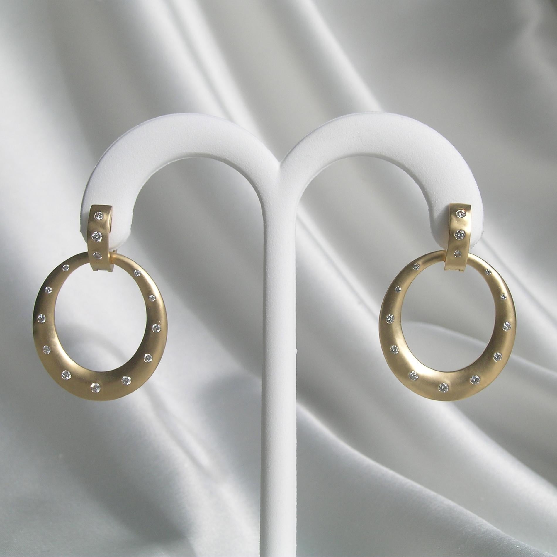 A unique hoop earring design, they face forward  The double hoop design allows the bottom hoop to move so it faces forward and to the side.  The disc of gold is accented with smooth set diamonds.  There are over a half carat of diamonds used in