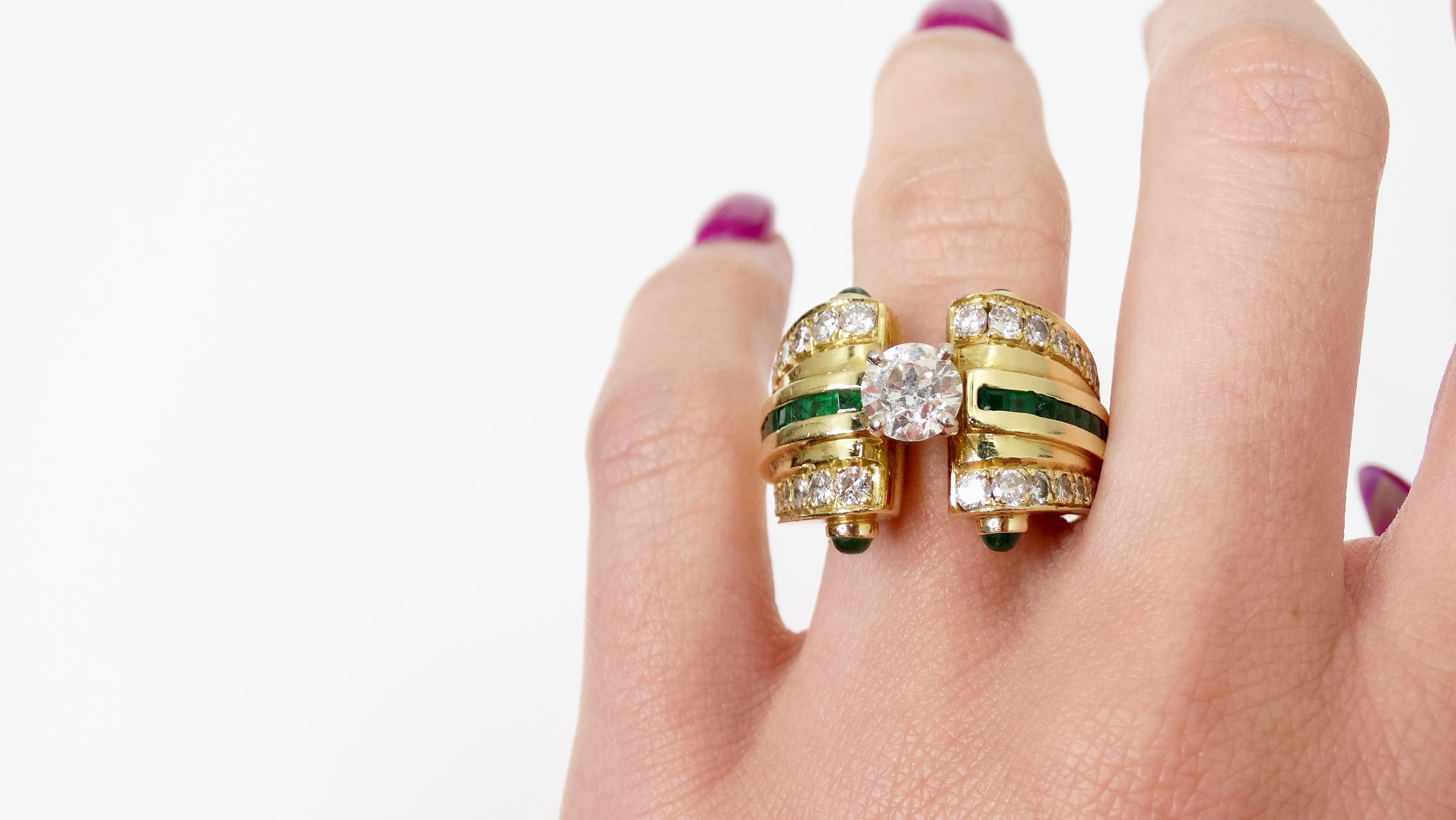 Bring on the cocktail! Circa 1950s, this stunning cocktail ring is crafted from 18k gold and features a thick tension band. In the center of the ring is a brilliant round cut 1.2ct diamond. Ring includes two cabochon cut Colombian Emeralds, two rows