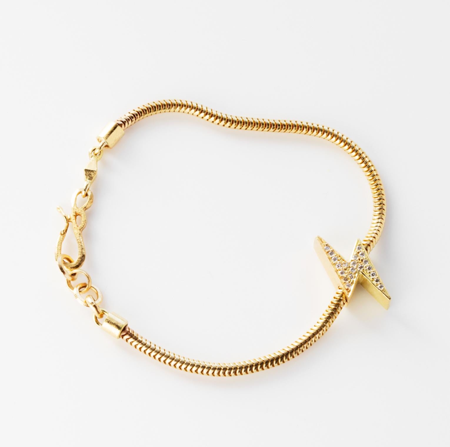 18k Lightening Bolt Snake Chain Bracelet features a White Diamond pave Lightening Bolt charm secured onto a solid gold snake chain bracelet, along with a clasp closure that secures the bracelet onto the wearer's wrist. 
18k Yellow Gold, White