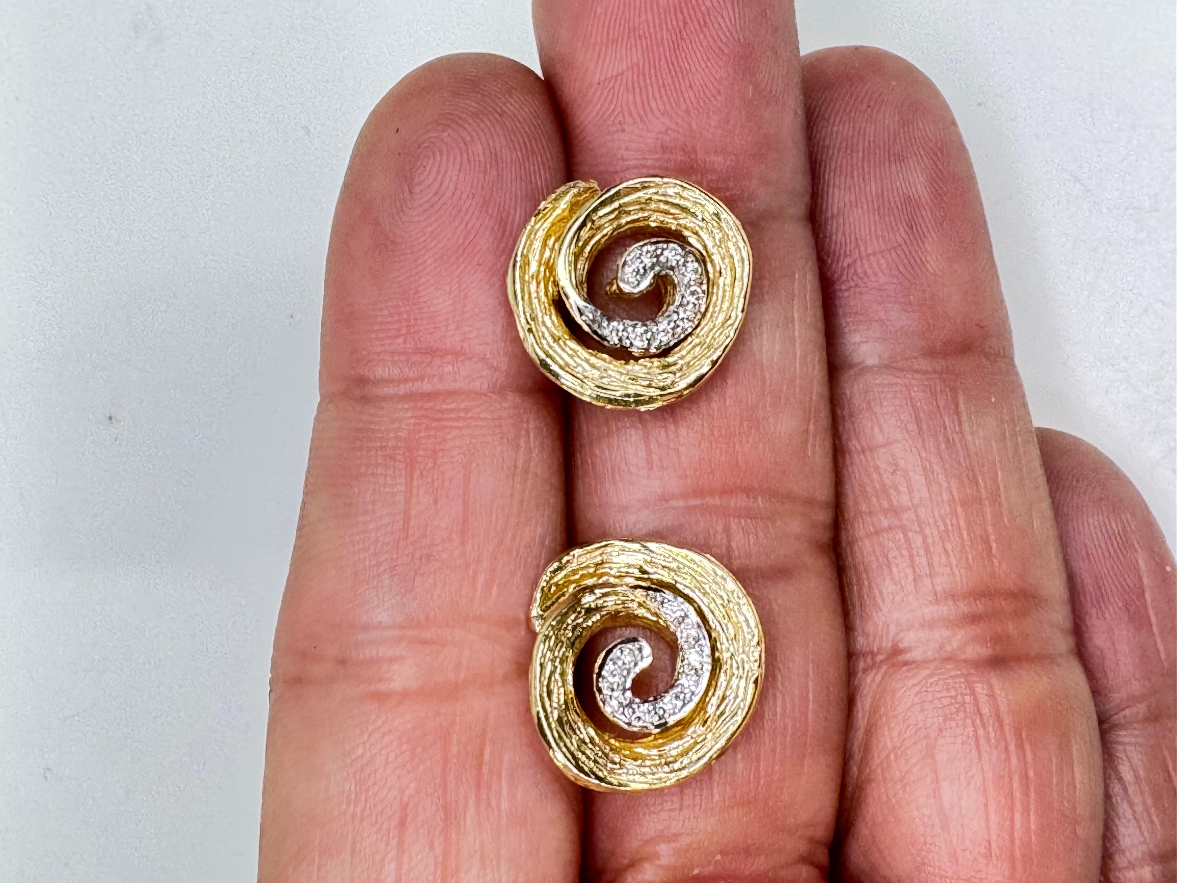 These striking stud earrings are crafted in luxurious 18k gold and feature a captivating Redgillite center, surrounded by a halo of 18 sparkling mini diamonds. Enhanced with rhodium detailing, the diamonds shine with added brilliance, creating a