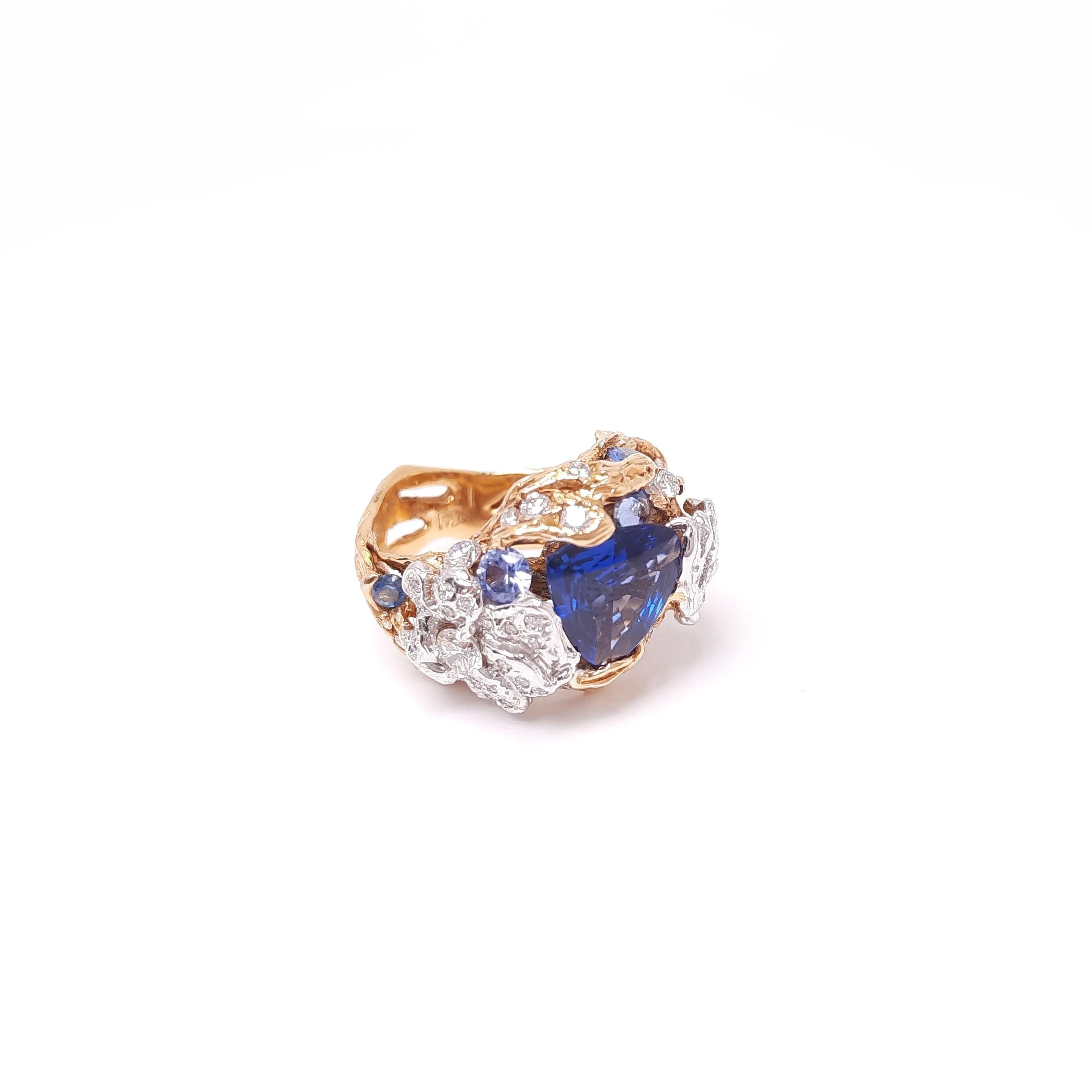 Each creation from MOISEIKIN®  is unique, colourful, and inspirational. 
A fancy cut sapphire is mounted in a handmade design of 18karat gold. Twig-like gold filigree and iris flower petal prong together hold the central sapphire gently, making your