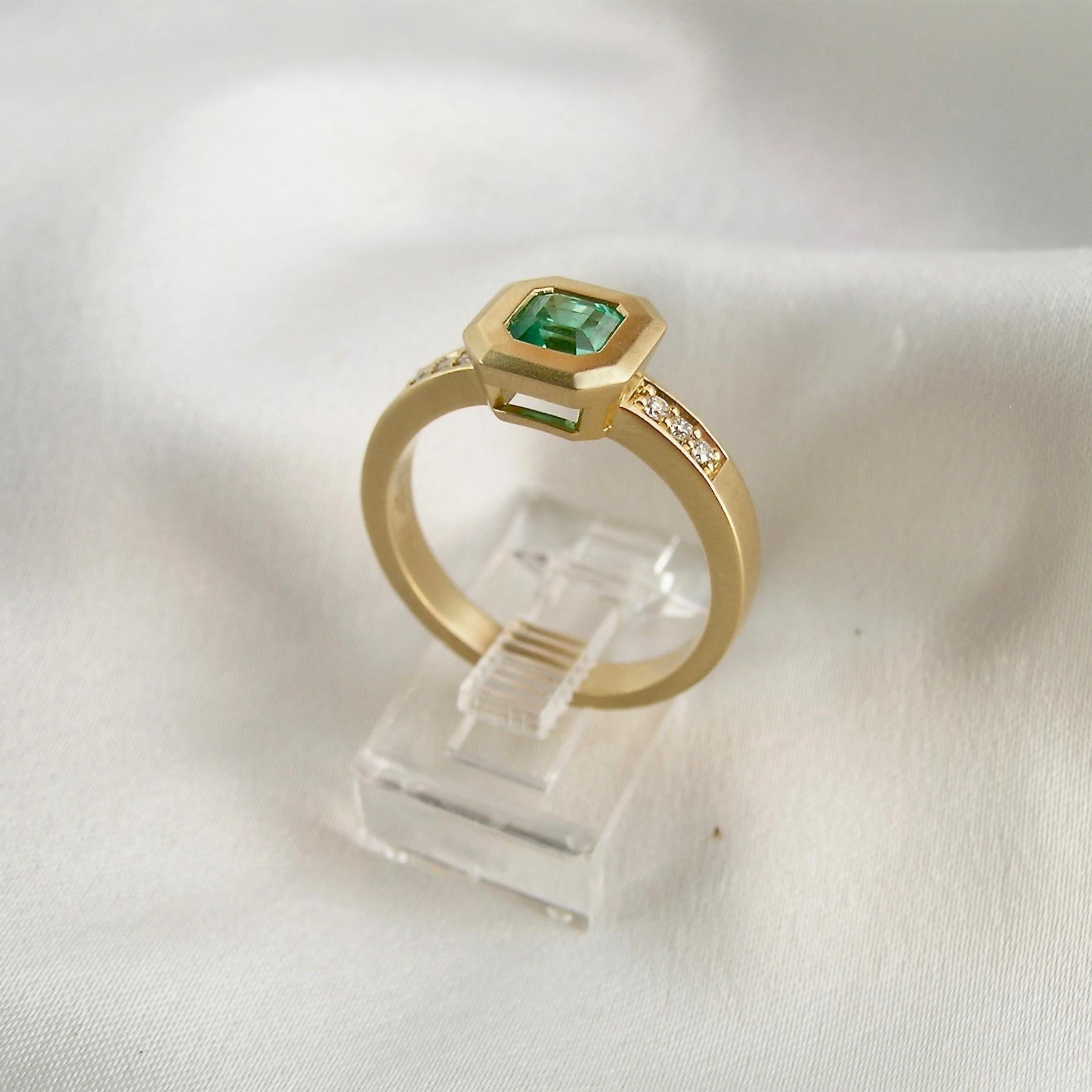 Nancy has set this sweet 0.60ct Columbian Emerald in a simple, yet elegant setting.  Her signature satin finish is a perfect canvas for the emerald.  The Emerald is small, but very clean and brilliant.  0.06cts of Diamonds are a nice accent on the