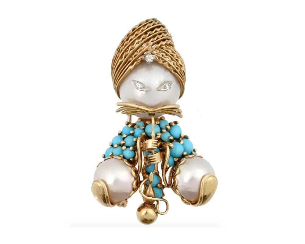An 18K Yellow Gold and Gemstone brooch by Dessin Dessin, Paris. The brooch is designed as a snake charmer. The ware set with turquoise cabochons of various sizes, and three mabe pearls, and decorated with engraved accents. The brooch is encrusted