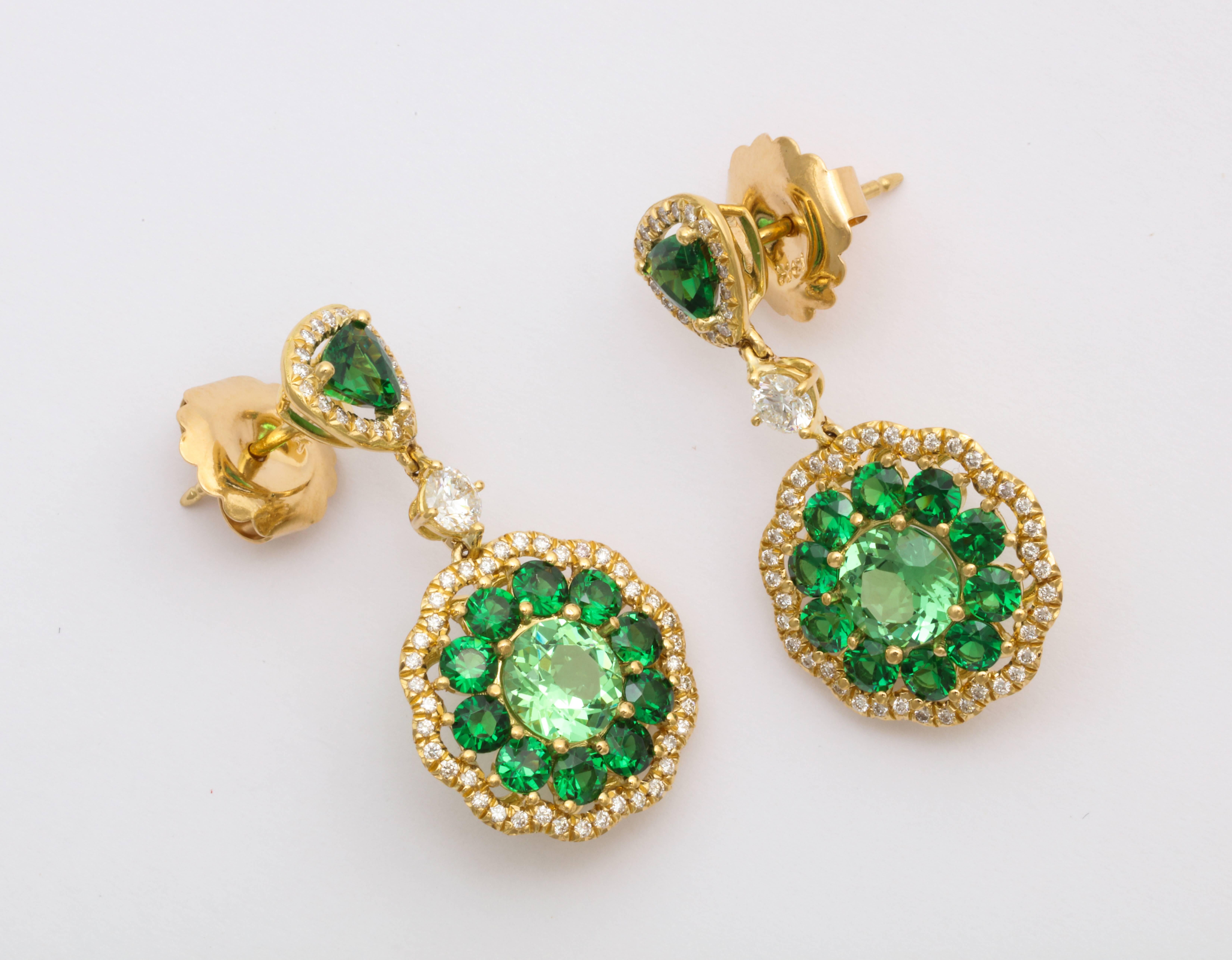 Say it with color! These 18K Yellow Gold earrings by world renowned designer Donna Vock are composed of the finest quality Tsavorite (garnet), in three shades of the most vivid, festive green and accented with superb round brilliant diamonds. 