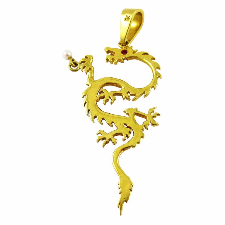 Dragon pendant in 18k yellow gold with a .02 carat ruby eye and a seed pearl