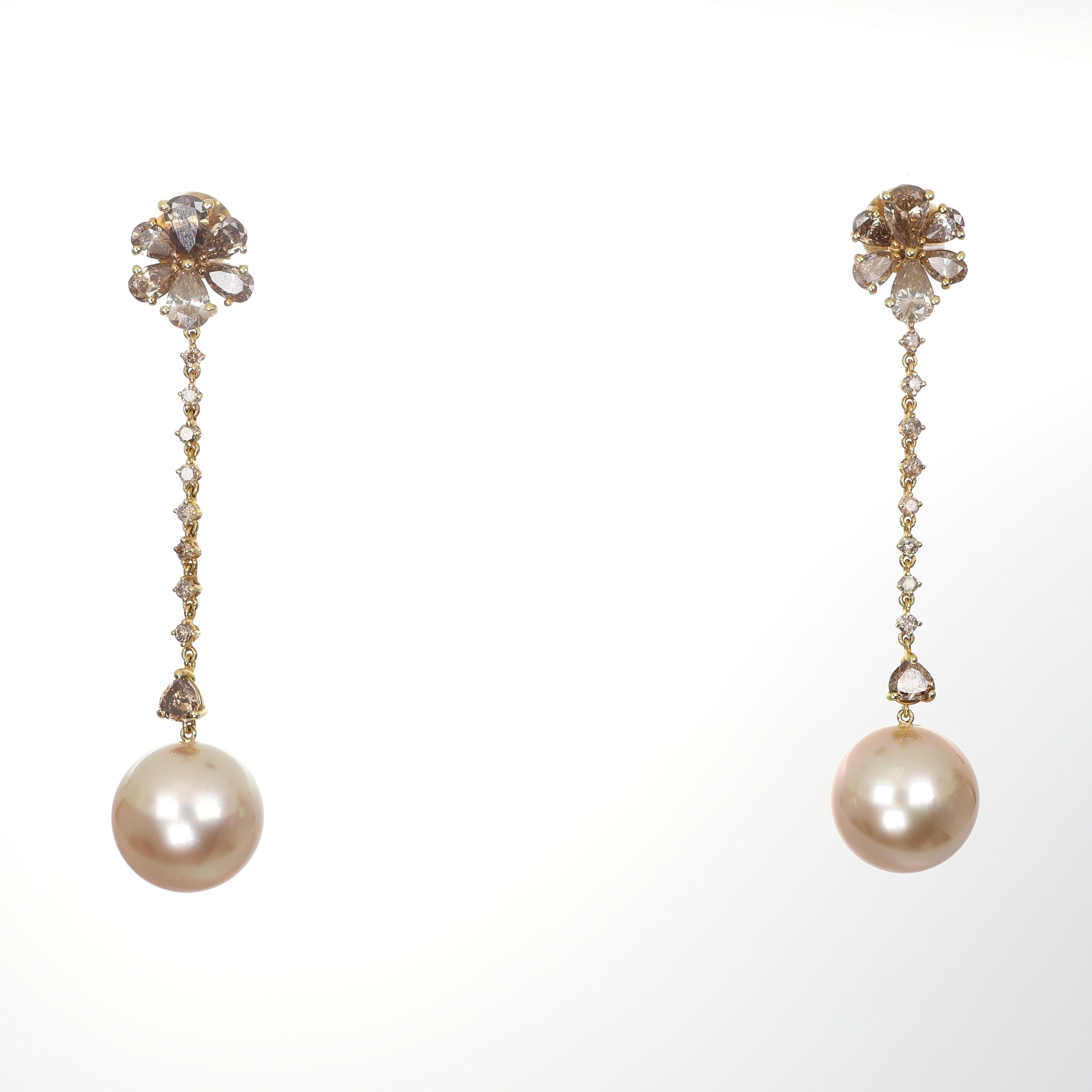 Elegant and refined, these 18K gold drop earrings feature a delicate floral motif adorned with champagne diamonds, leading to a cascade of diamond-set links that end with luminous yellow pearls. The soft golden hue of the pearls harmonizes