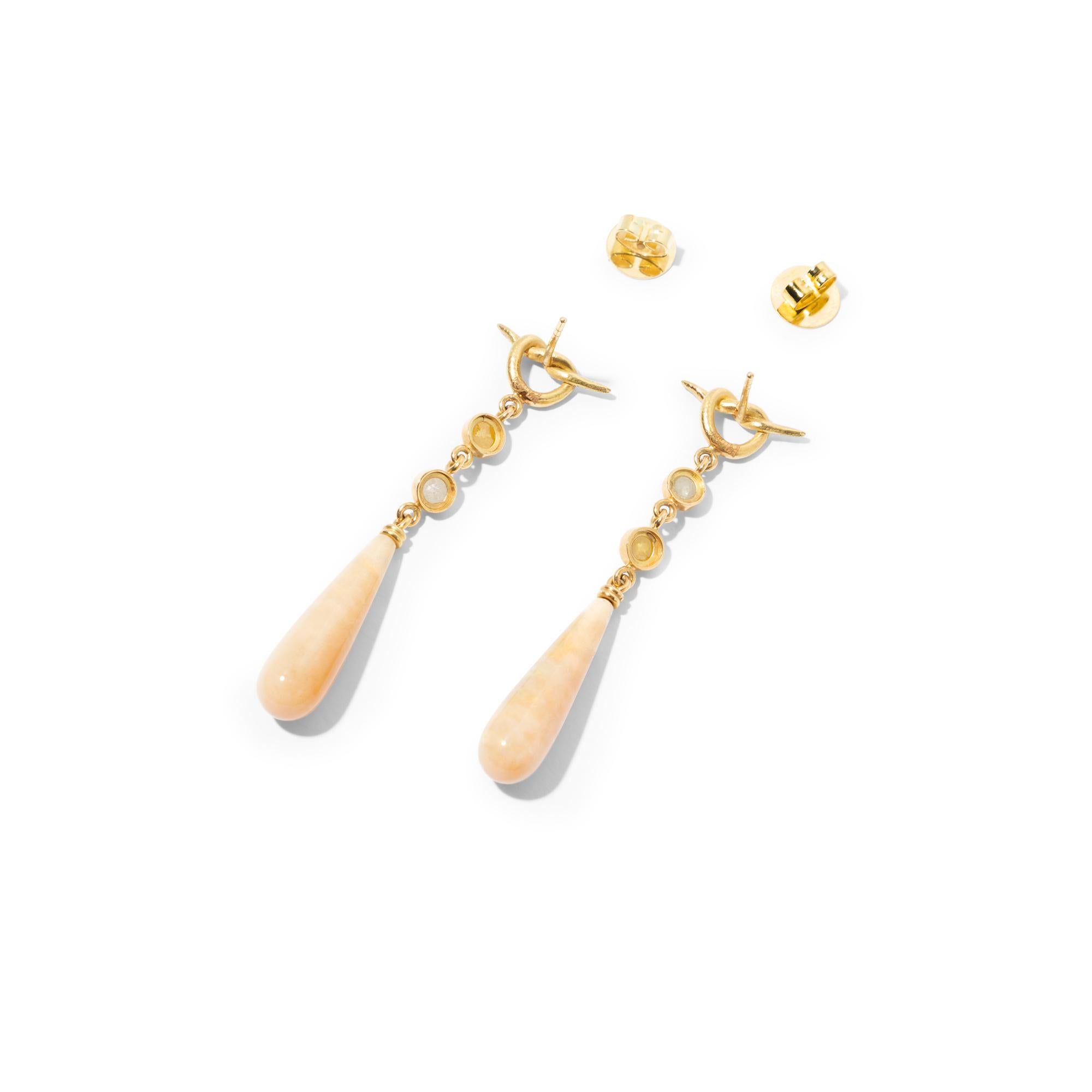 An exquisite pair of 18k gold earrings featuring long honey opal drops of exceptional beauty and light grey and yellow rose cut diamonds in an asymmetric colour combination which amplifies the opals' natural splendour. The gemstones are suspended
