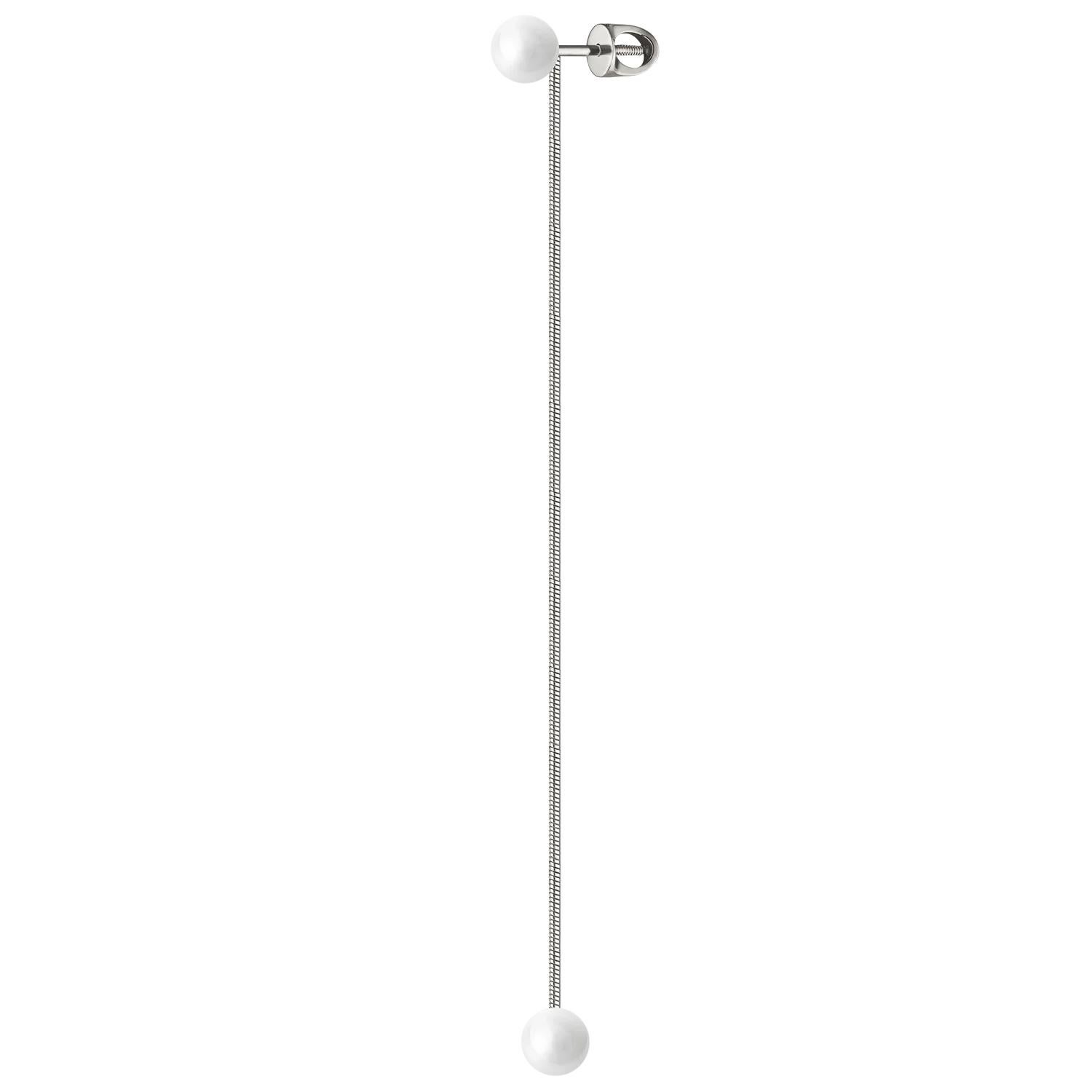 N 9 es un pendiente que captura la elegancia del movimiento a través de una composición sencilla pero poética: perlas suspendidas en una fina cadena. Cada perla se balancea suavemente con el cuerpo, creando un movimiento sutil y rítmico que evoca